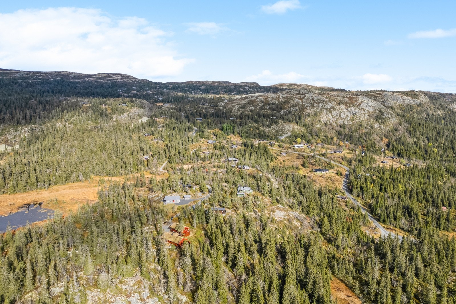 Oversiktsbilde av eiendommen med bakenforliggende fjellpartier Galleribilde