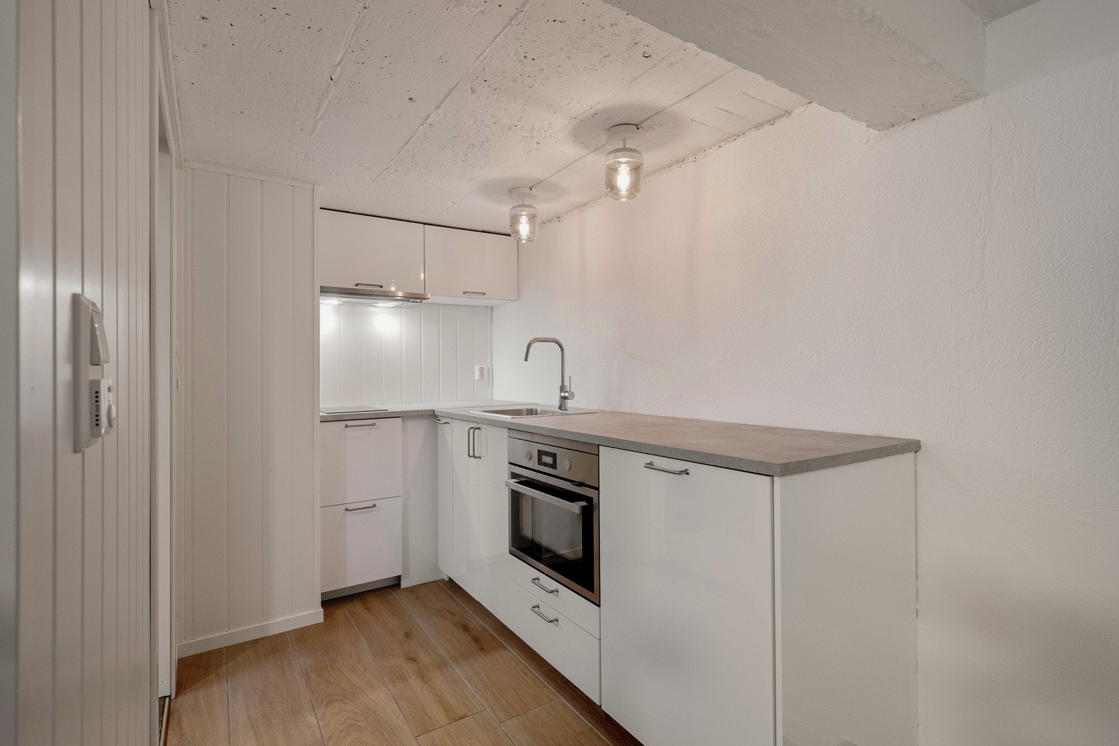 Kjøkkenet har innredning med glatte fronter og benkeplate av laminat. Det er oppvaskmaskin, platetopp og stekeovn Galleribilde