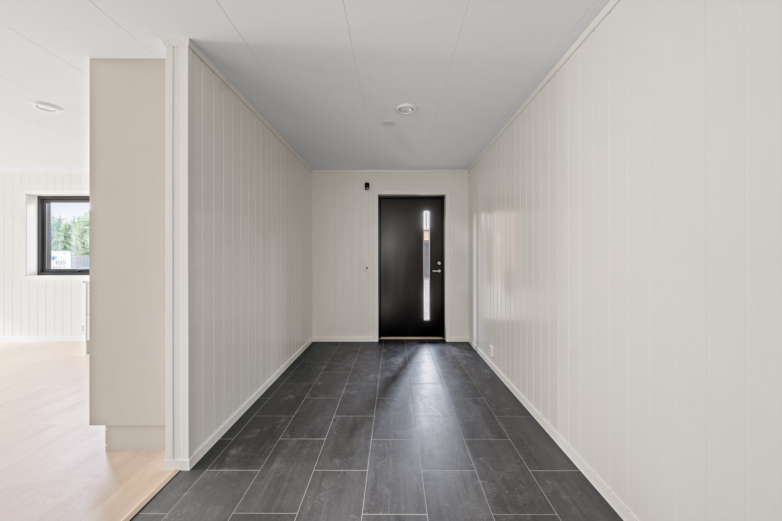 Boligen ønsker deg velkommen med en lys og flislagt entré med varmekabler i gulvet - praktisk på kalde dager. Galleribilde