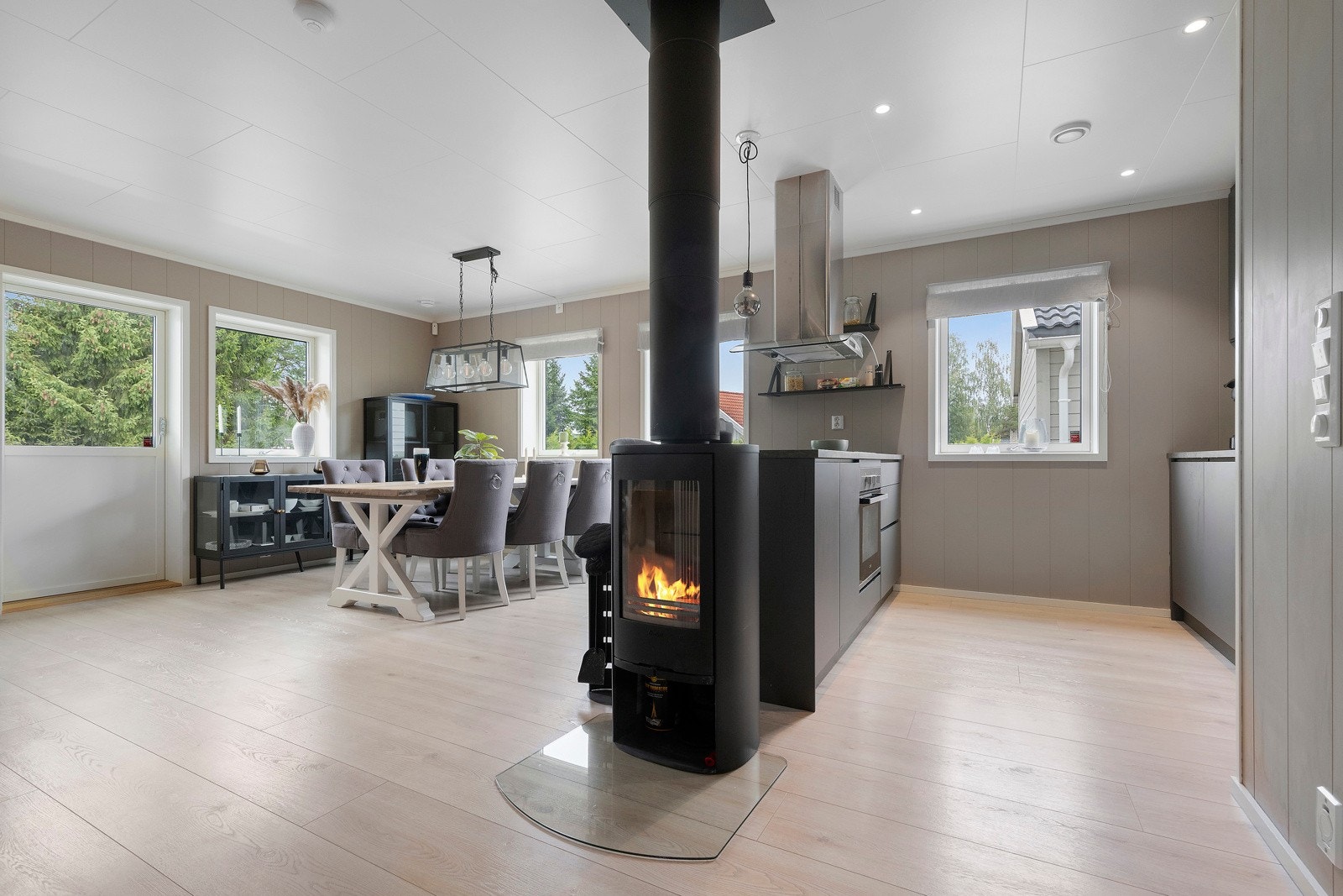 Sentralt i rommet er det vedovn som gir ekstra oppvarming og hygge. Galleribilde