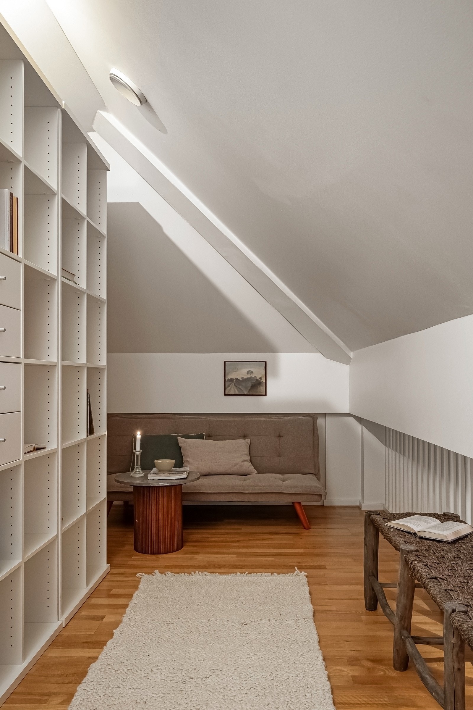 Hemsen har stor plassbygget bokhylle langs hele veggen og det er rom for en liten sittegruppe eller skrivepult Galleribilde
