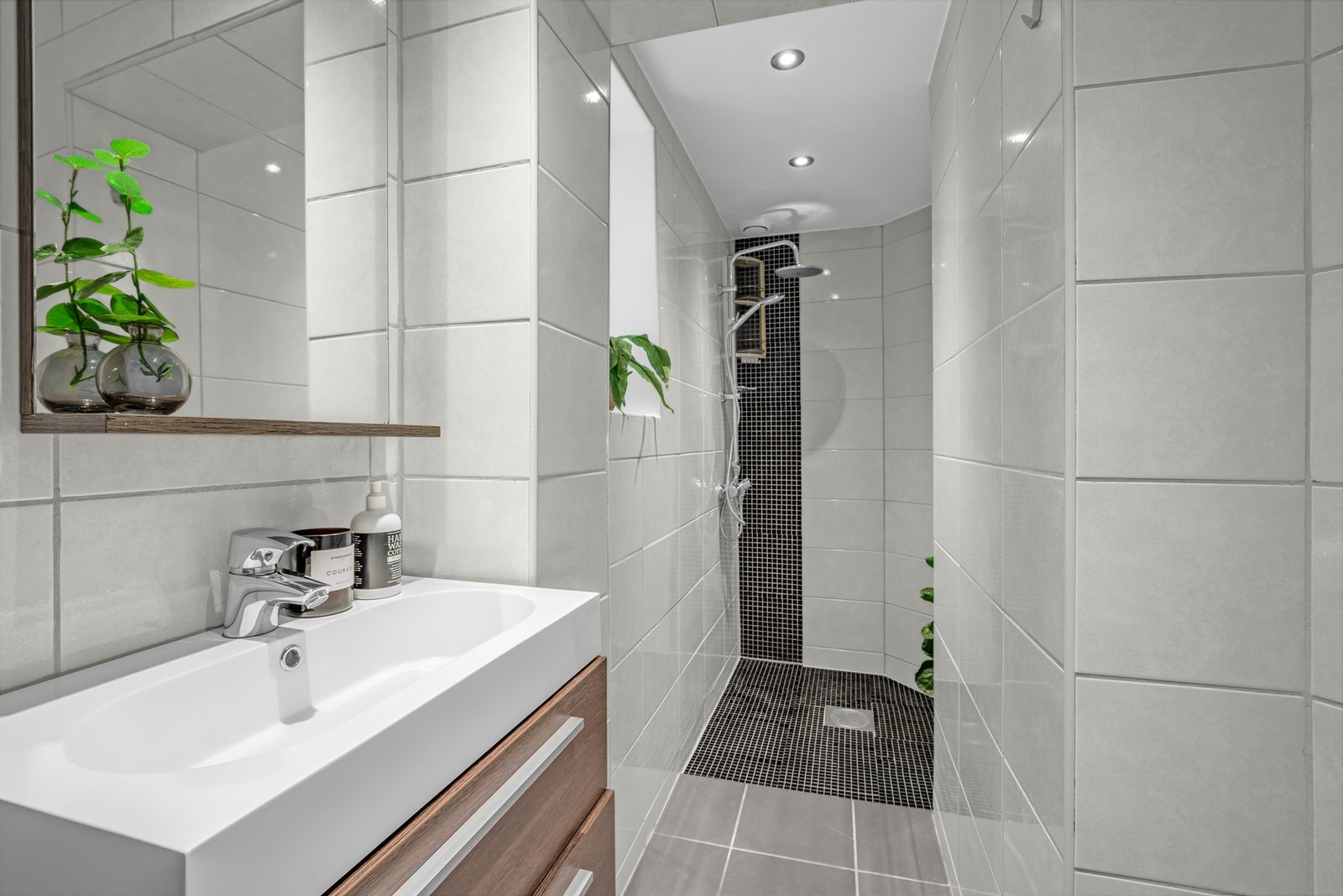 Det delikate badet har en pen og praktisk nisje hvor mosaikkfliser markerer dusjsonen. Galleribilde