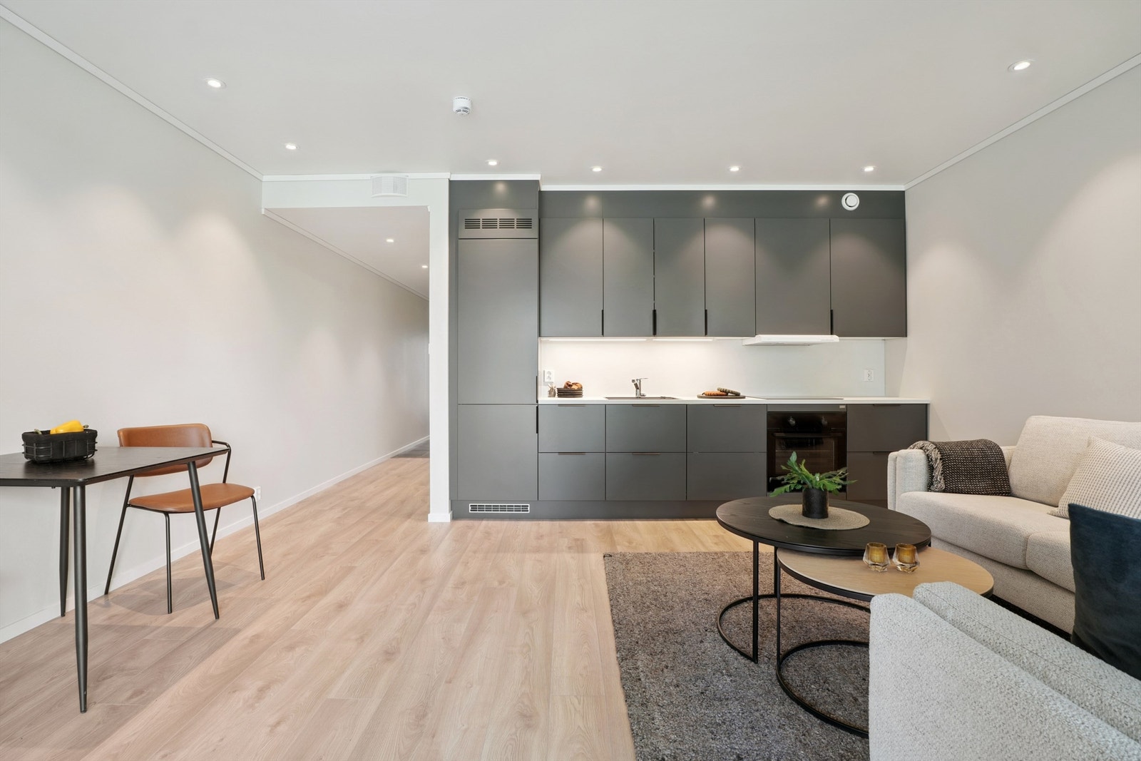 Leilighetens sosiale sone består av stue og kjøkken i en åpen, moderne løsning. Galleribilde