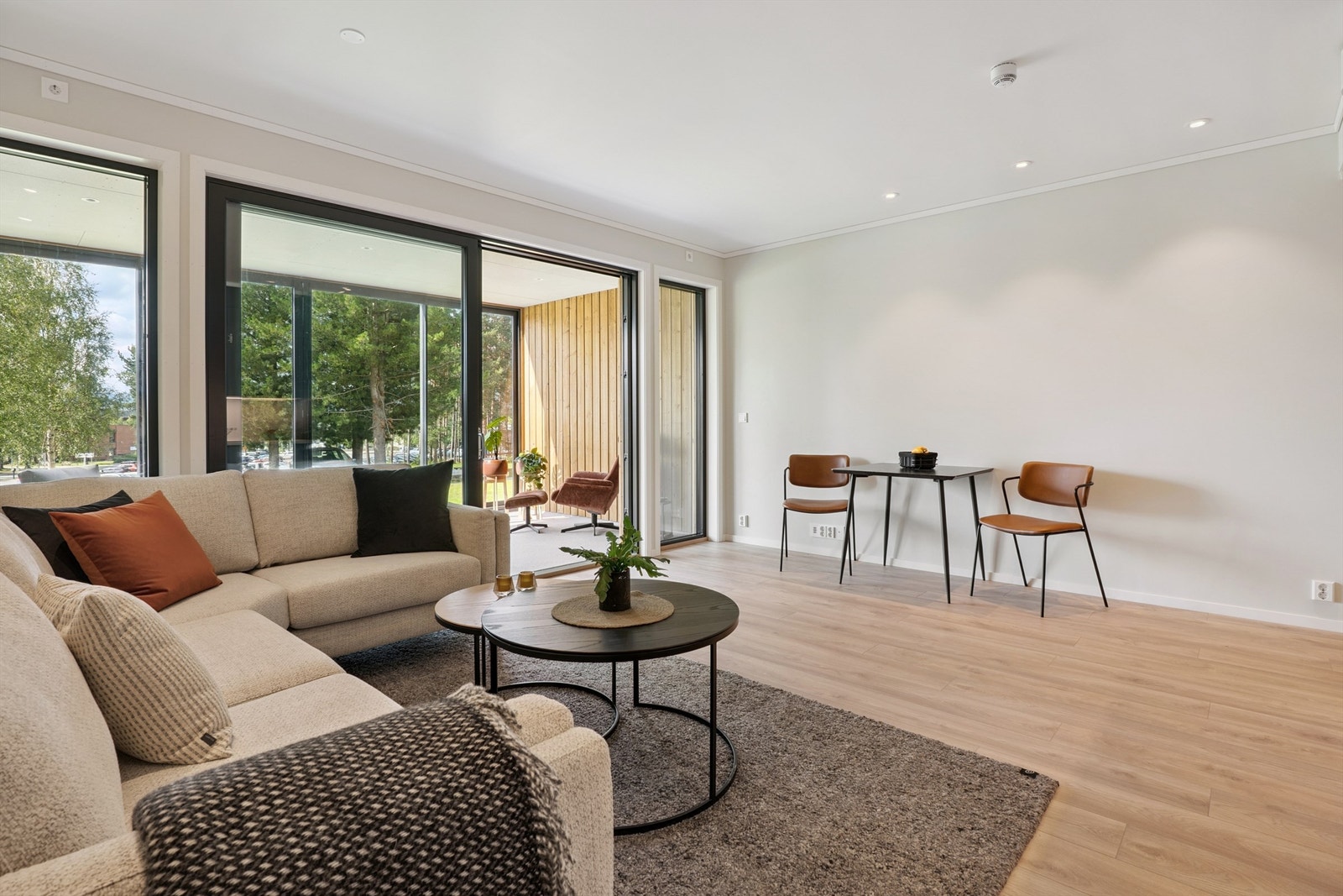 Store vindusflater og skyvedør i glass gir rikelig med lys og en sømløs overgang til den innglassede verandaen. Galleribilde