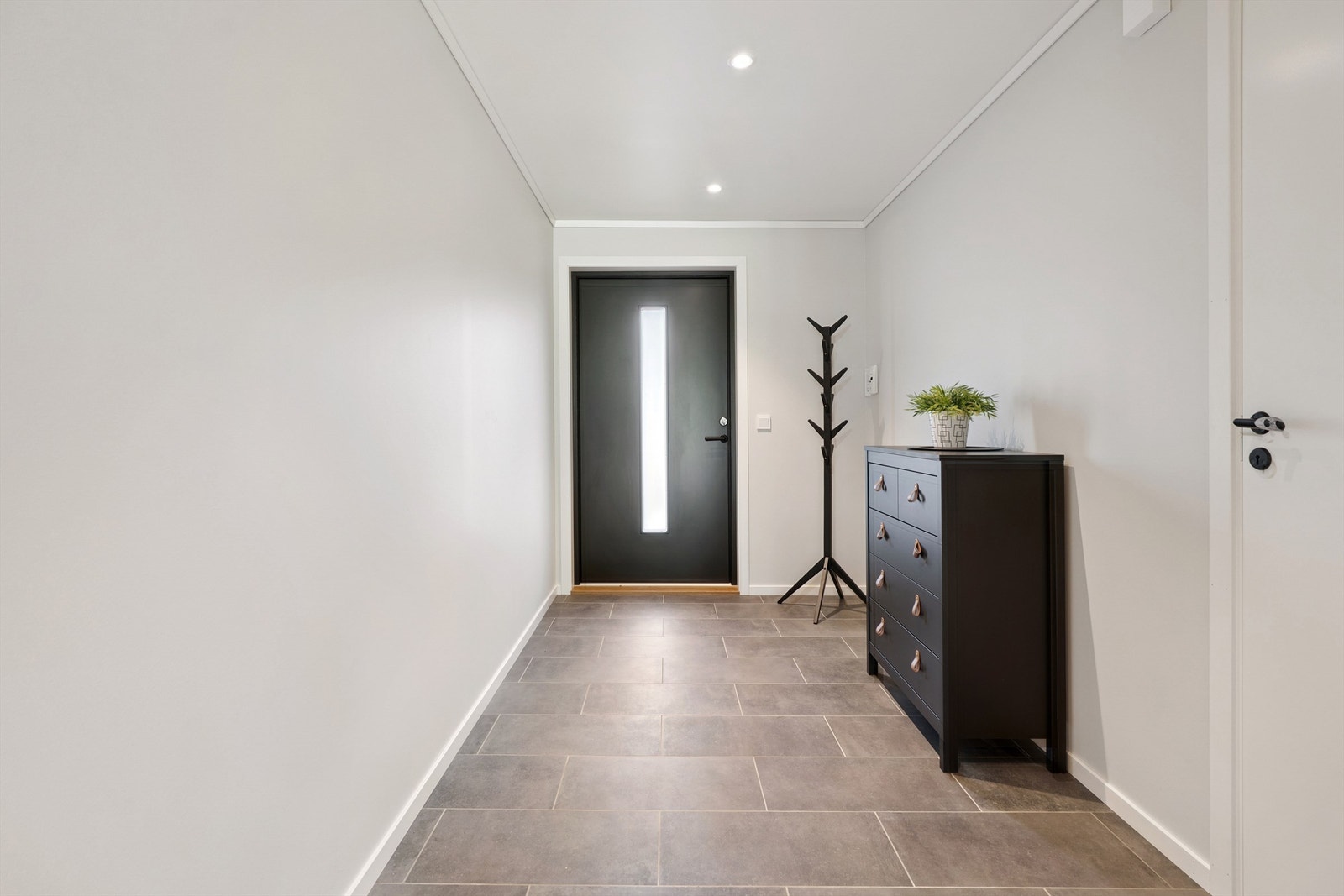 Flislagt bred gang/hall med god plass for garderobeskap. Galleribilde