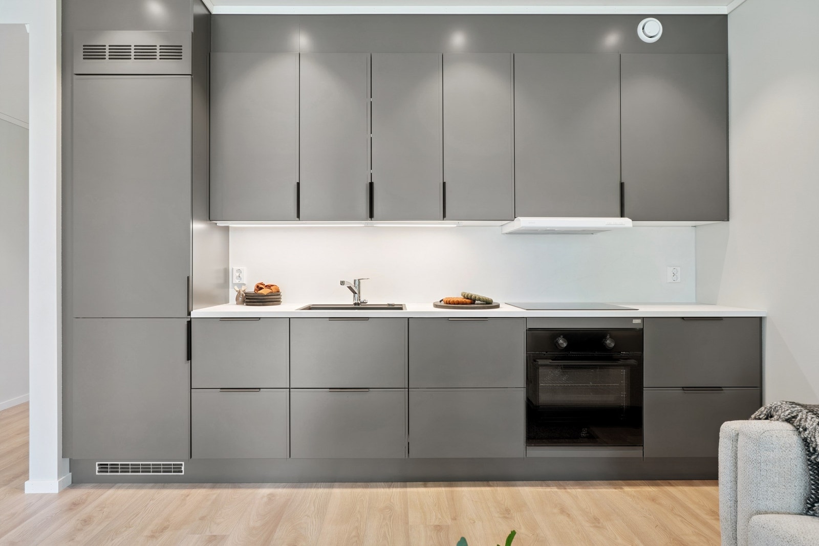 Kjøkkeninnredningen fra Huseby av modellen Pinje har et stilrent uttrykk med slette fronter og godt med skapplass. Integrerte hvitevarer. Galleribilde