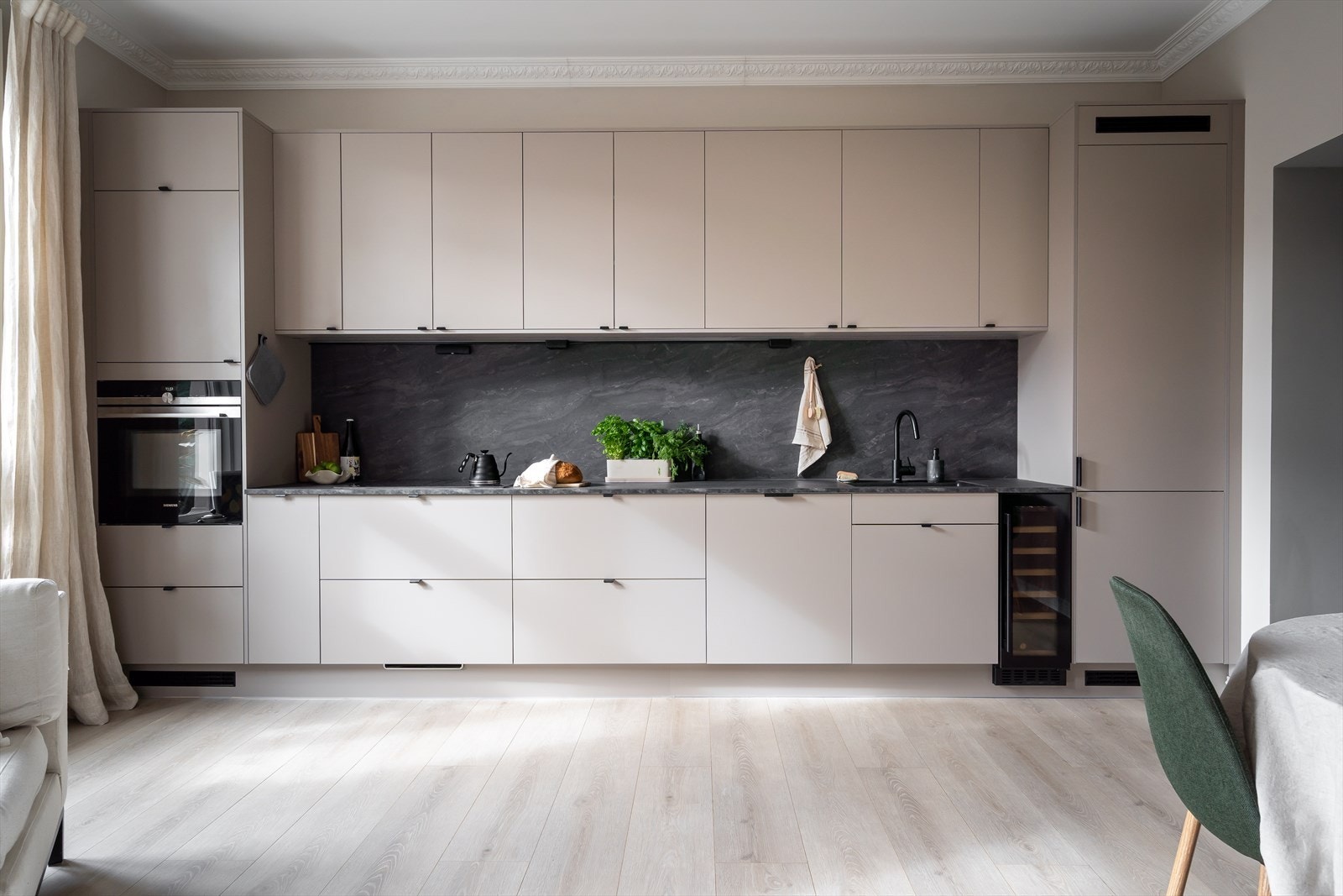 Veggplater i samme design som benkeplaten gir et helhetlig uttrykk. LED-belysning under overskapene skaper en god arbeidslyssetting. Galleribilde