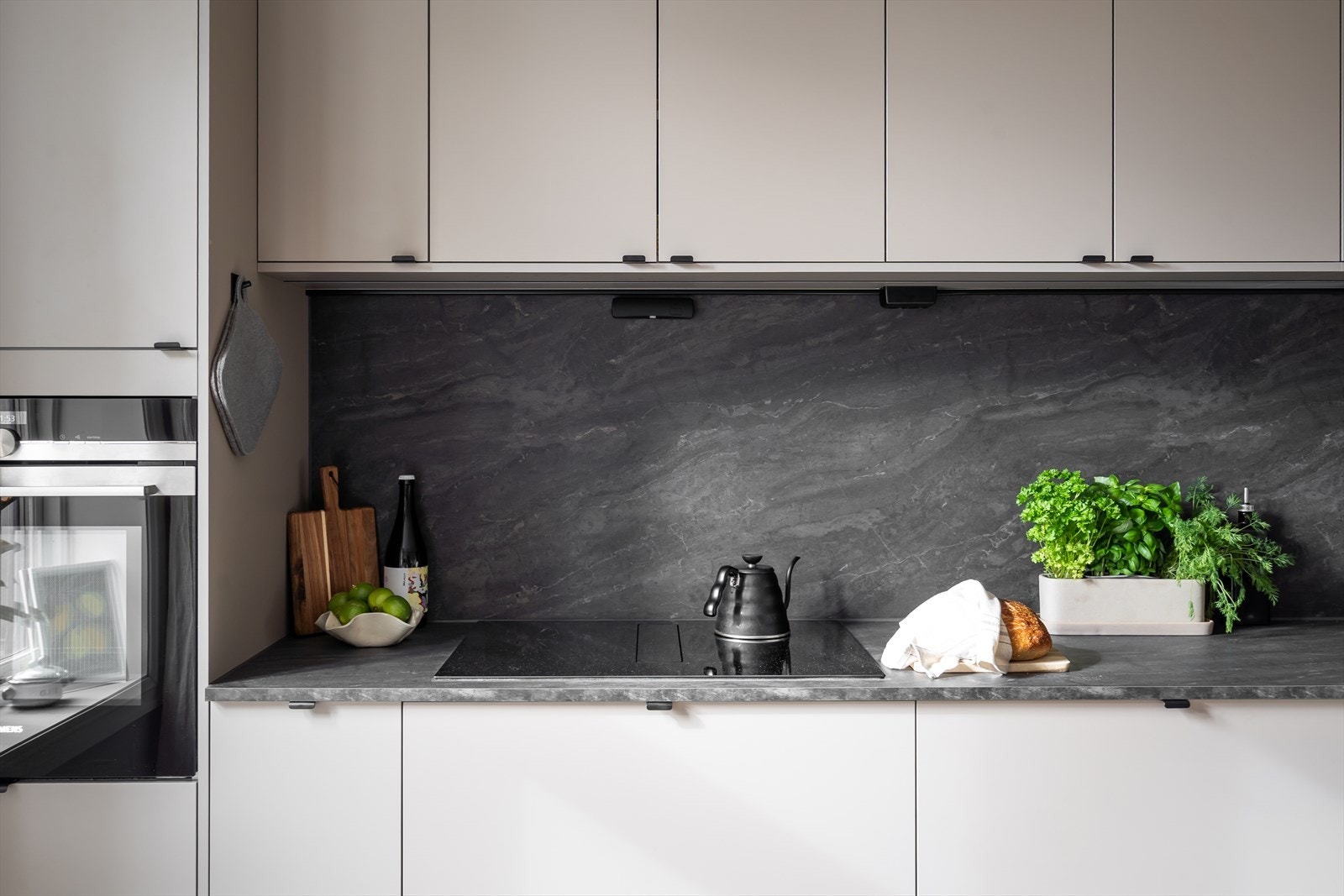 Kjøkkenet er fullt utrustet med integrerte hvitevarer: induksjonstopp, ventilator, stekeovn, vinskap, oppvaskmaskin og kombiskap kjøl/frys. Det er montert komfyrvakt og aquastop. Galleribilde