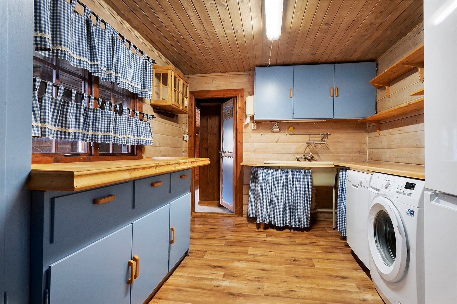 Vaskerommet er praktisk innredet med skap, benker og hylleinnredning. Galleribilde