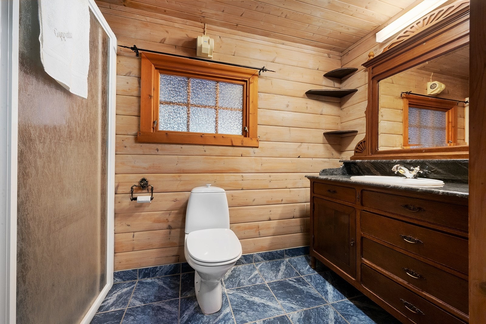 Badet er innredet med WC, dusj og baderomsinnredning med servant. Galleribilde