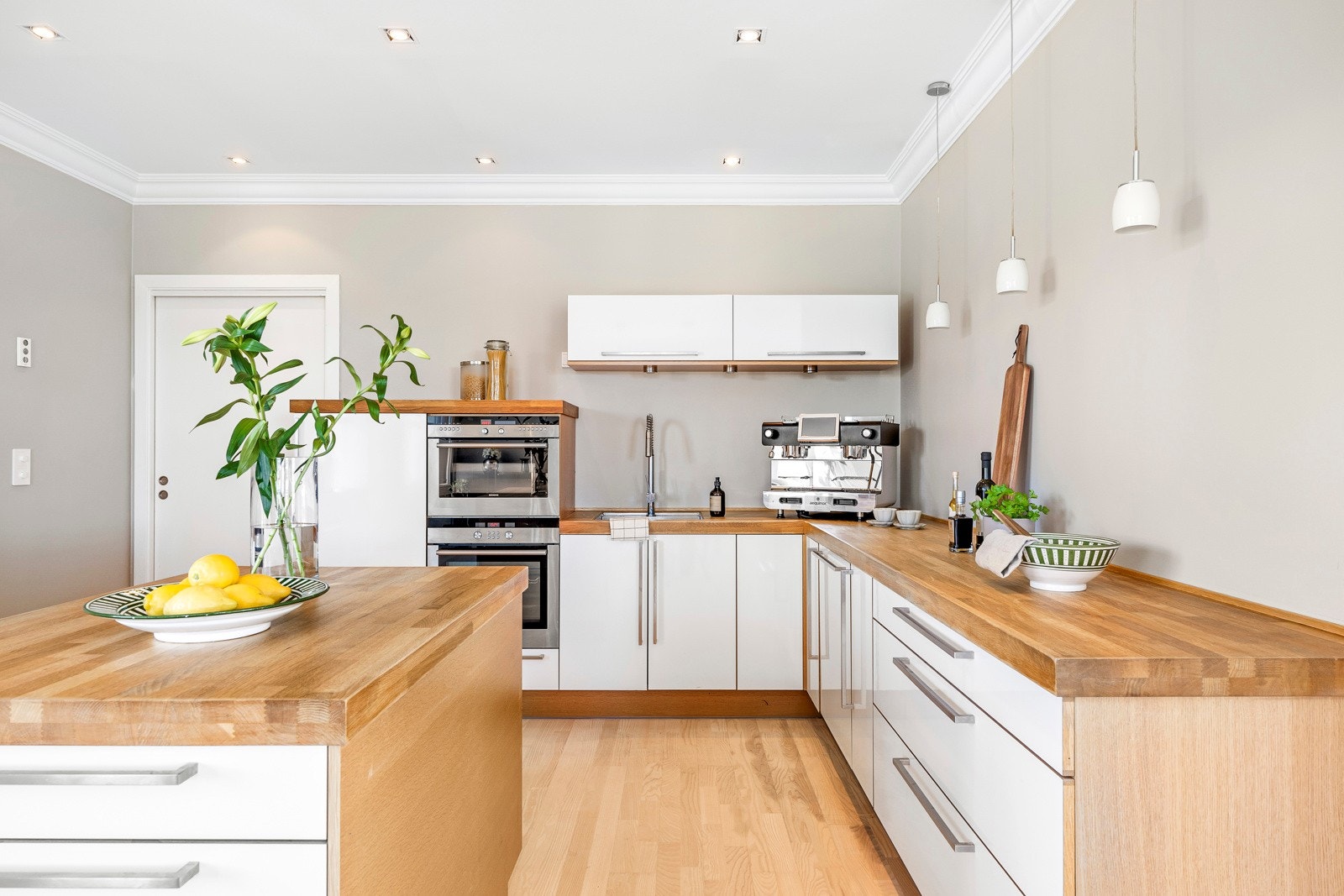 Innredningen har hvite, glatte fronter og solid, gyllen heltrebenkeplate med nedfelt kum i stål. Galleribilde