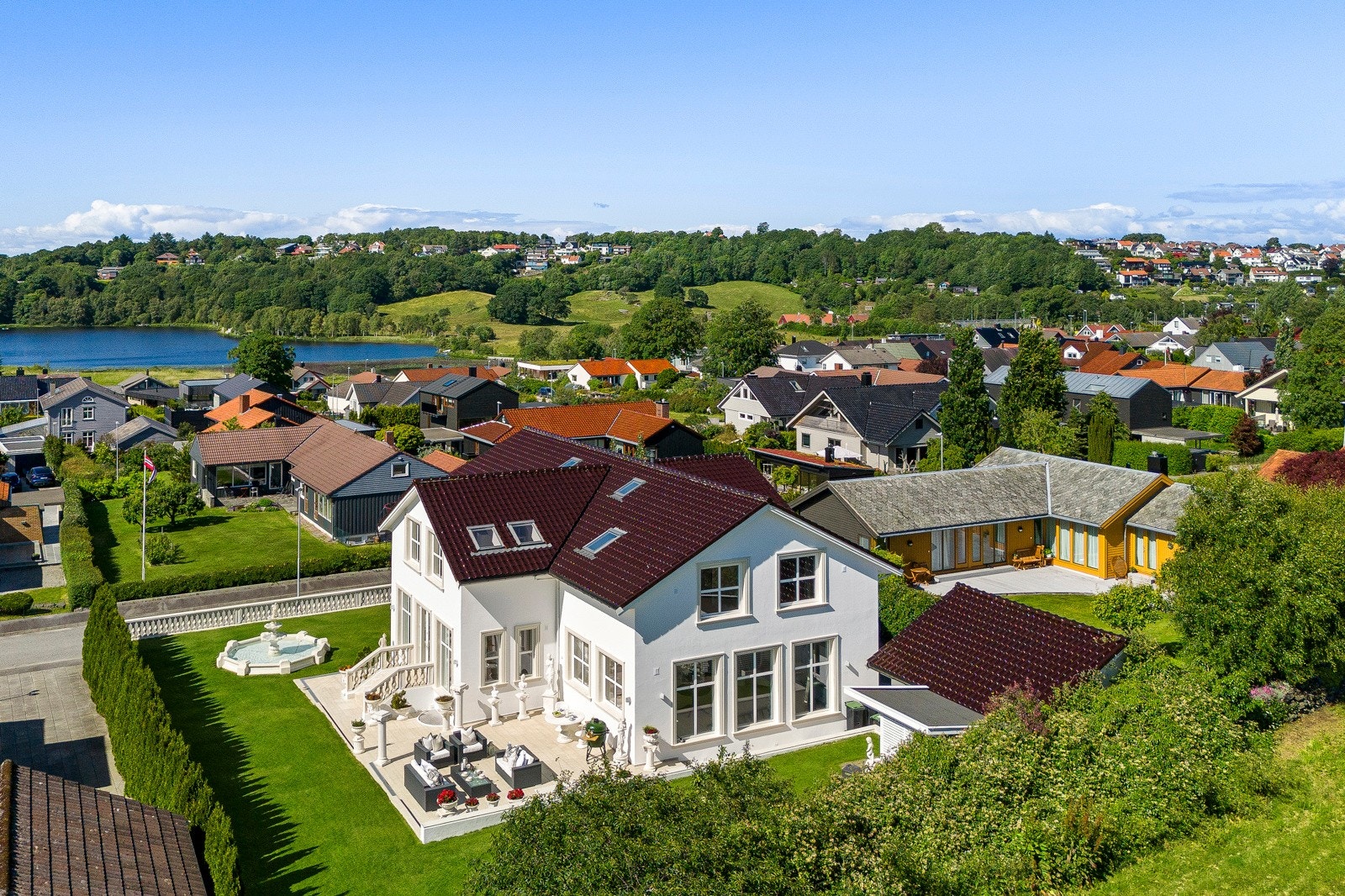 Boligen har en usjenert tomt, omringet av hekk og et gjerde som passer til husets uttrykk forøvrig. Galleribilde