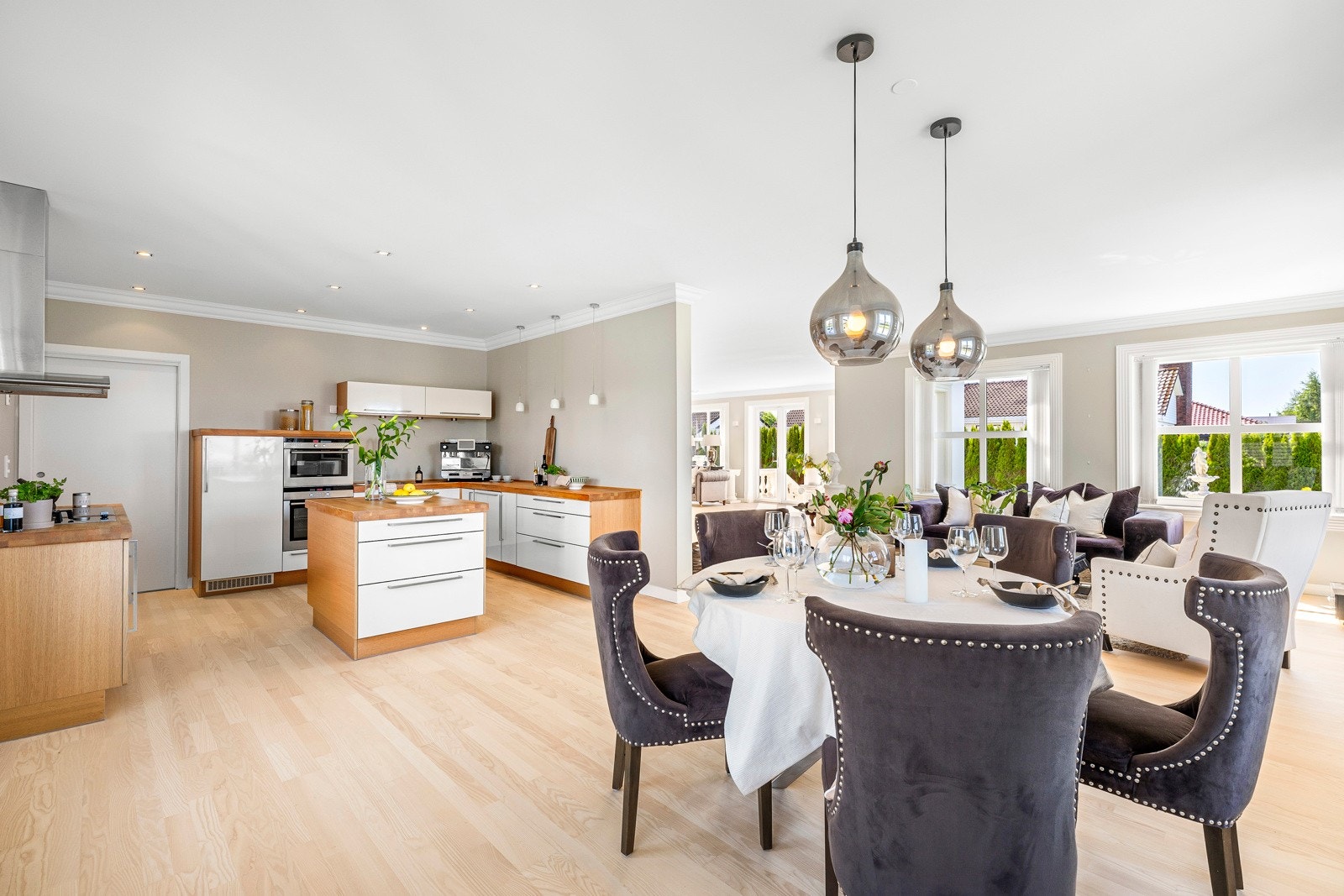 Stuen ligger i åpen løsning med kjøkkenet, og sammen danner de et stilfullt og innbydende allrom som dekker store deler av første etasje. Galleribilde