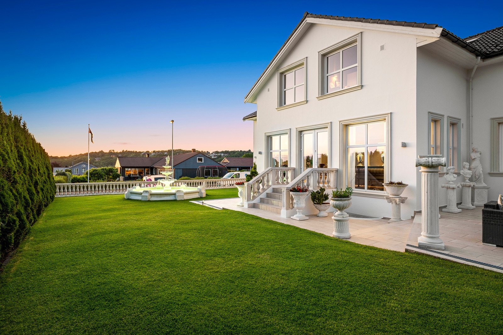 Markterrassen har flislagt dekke, og det er montert moderne utebelysing på husveggen. Galleribilde