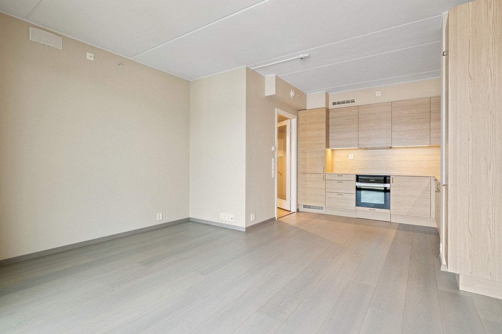 Åpen stue- og kjøkkenløsning med integrerte hvitevarer. Galleribilde