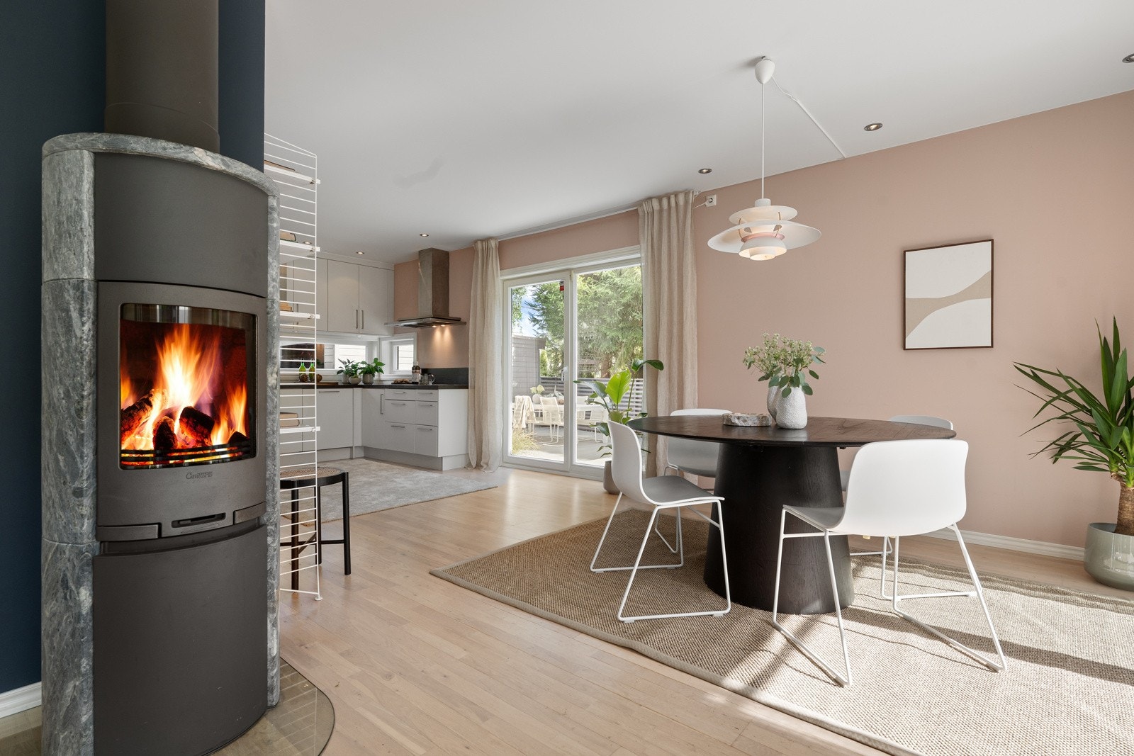 Spisestuen er tilkoblet to uteområder. Til venstre tilgang til terrasse med spiseplass, kjøkken og hage Galleribilde