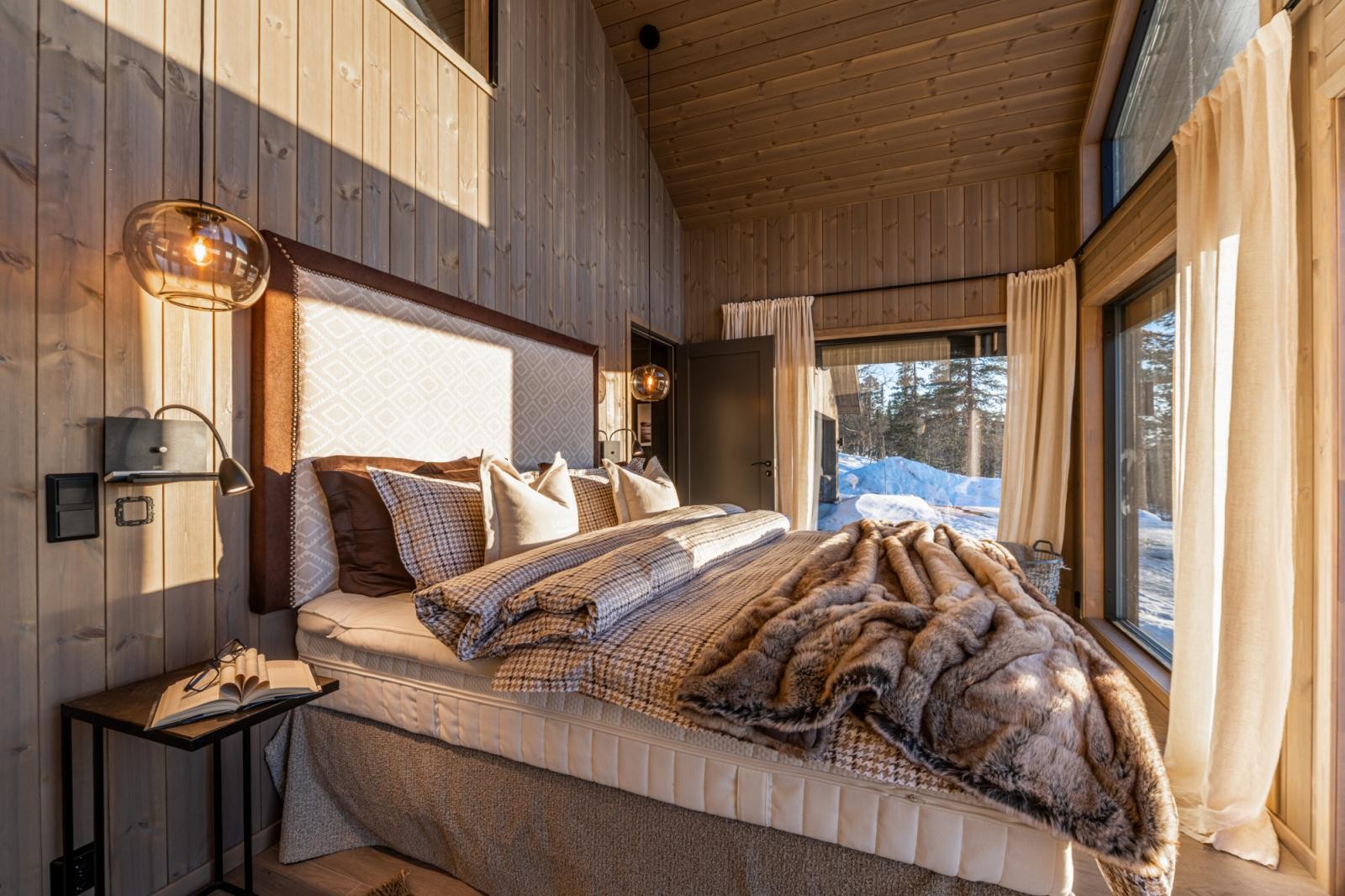 Master Bedroom er stort og eksklusivt. Her er det spesialsnekret hodegjerde i Andre Martin-stoff laget av Annette Nordstrøm og puter sydd i samme stoff levert av Alexia Lundgren Design. Galleribilde