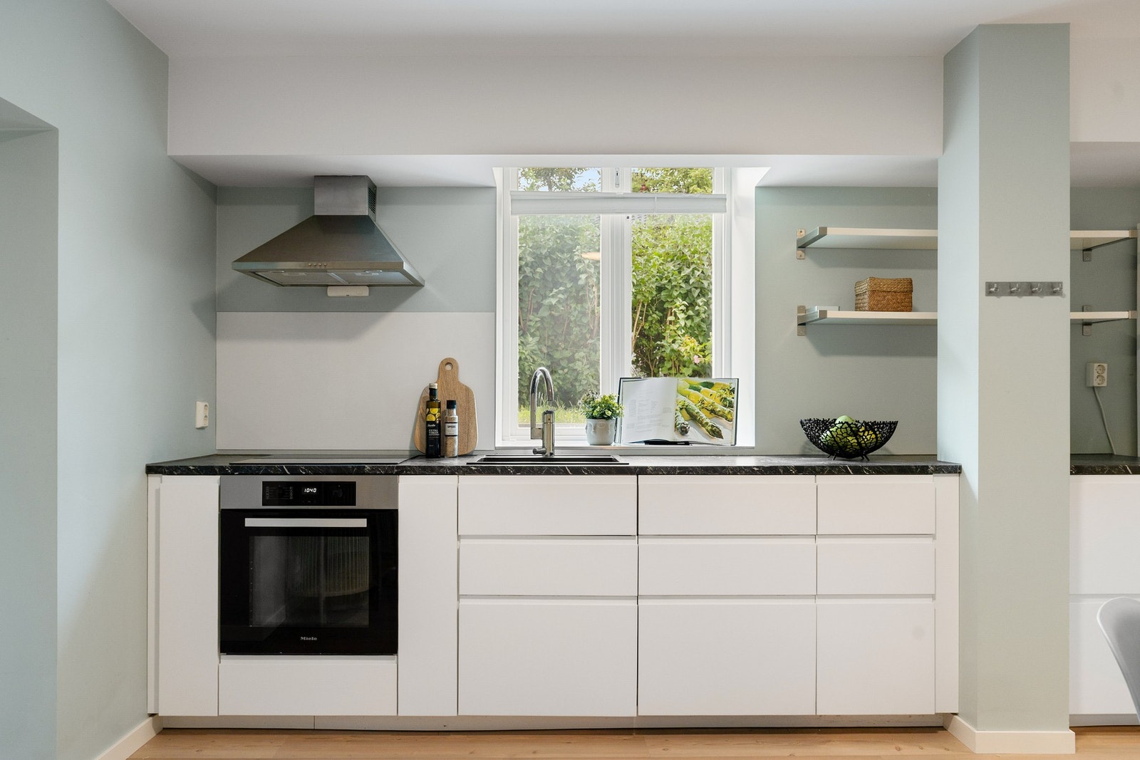 Vegger i malte flater. Himling i malt flate. Kjøleskap med fryser. Integrert oppvaskmaskin, stekeovn og induksjonstopp. Galleribilde