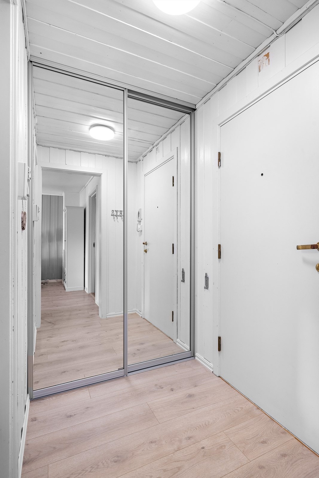 Adkomst fra felles trappegang til entre med skyvedørsgarderobe og dørcallinganlegg Galleribilde