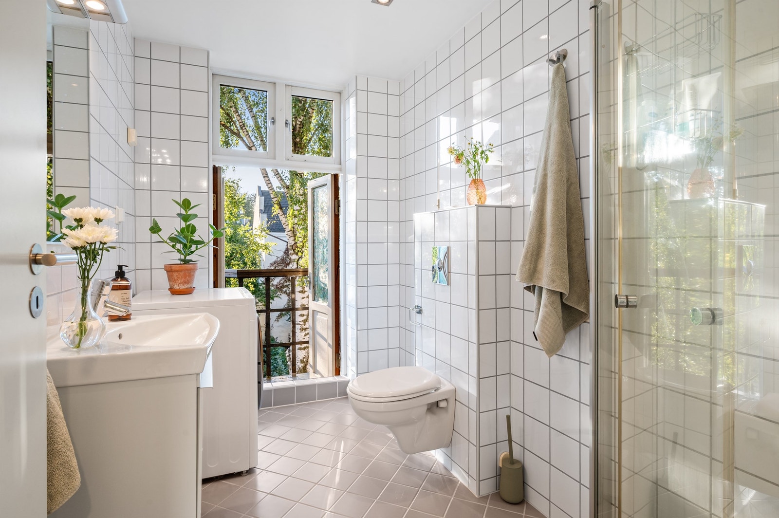 Pent flislagt bad med varme i gulvet som sørger for en behagelig start på dagen. Badet har dusjhjørne med svingbare glassdører og vegghengt klosett. Galleribilde