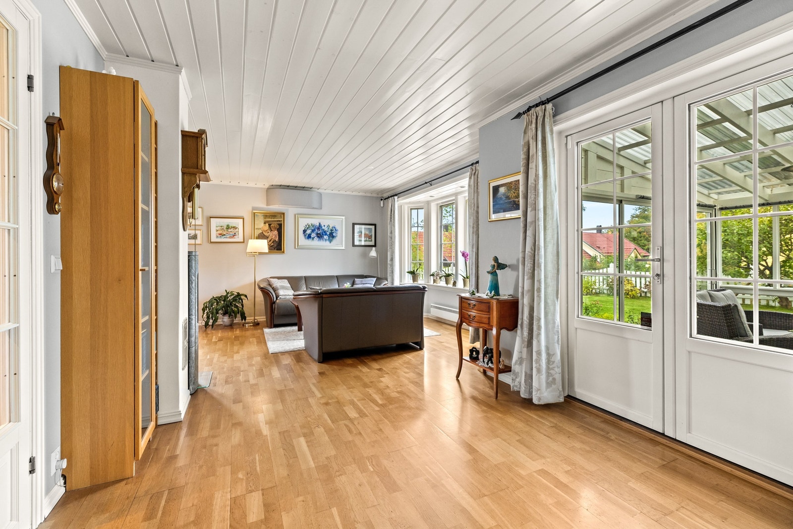 Fra stuen leder doble terrassedører ut til en hyggelig hagestue. Galleribilde