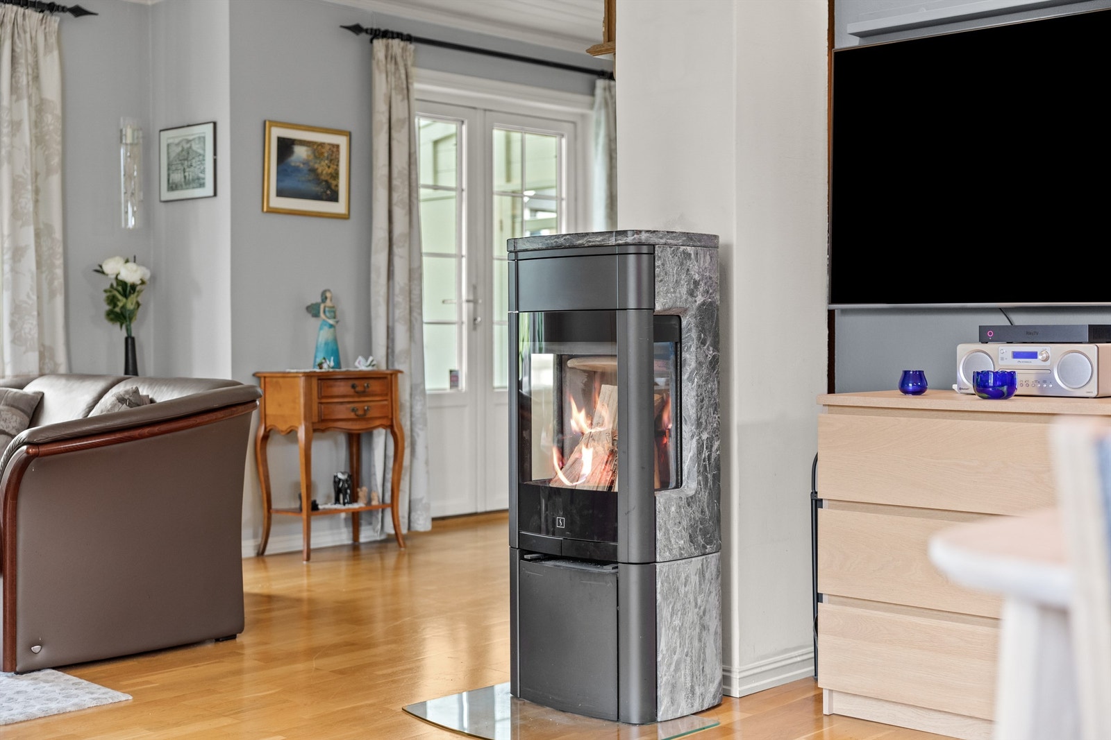 En peis sørger for både varme og lun stemning på kjølige dager, mens varmepumpen bidrar til jevn temperatur gjennom hele året. Galleribilde