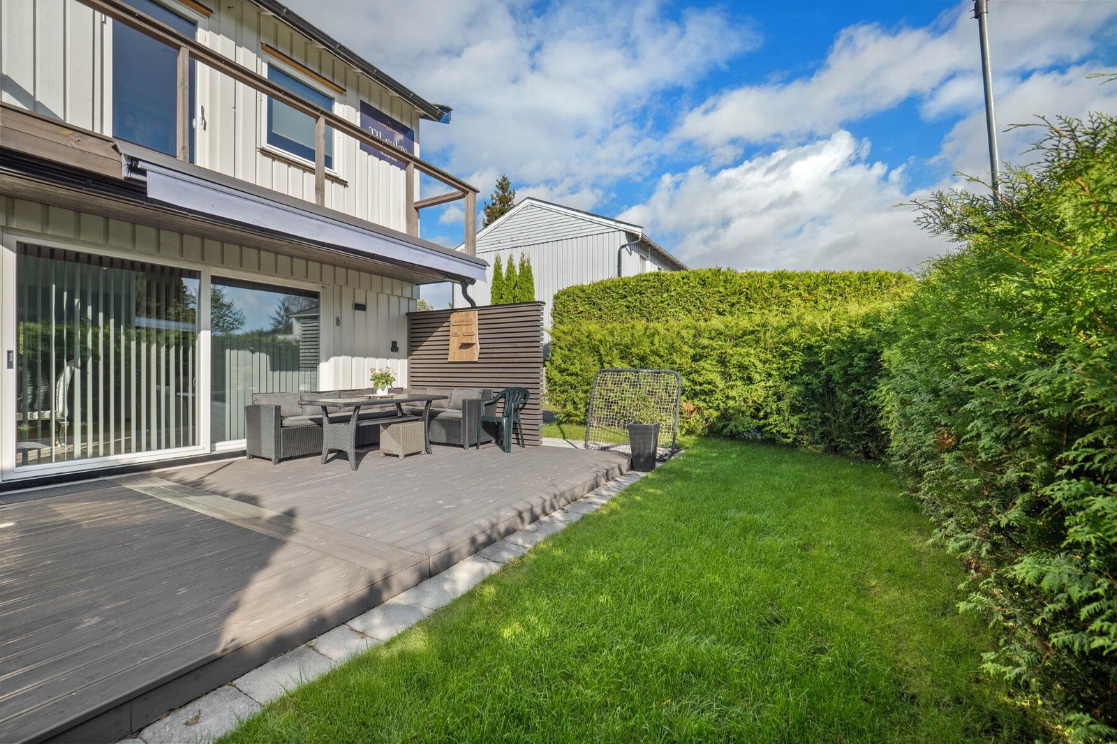 Mot syd er det en liten, koselig hage som rammes inn med tett, vintergrønn hekk. Galleribilde