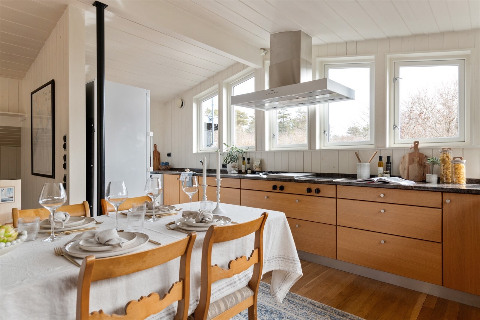 Pen kjøkkeninnredning i eik fra HTH med glatte fronter og benkeplate i stein. Galleribilde