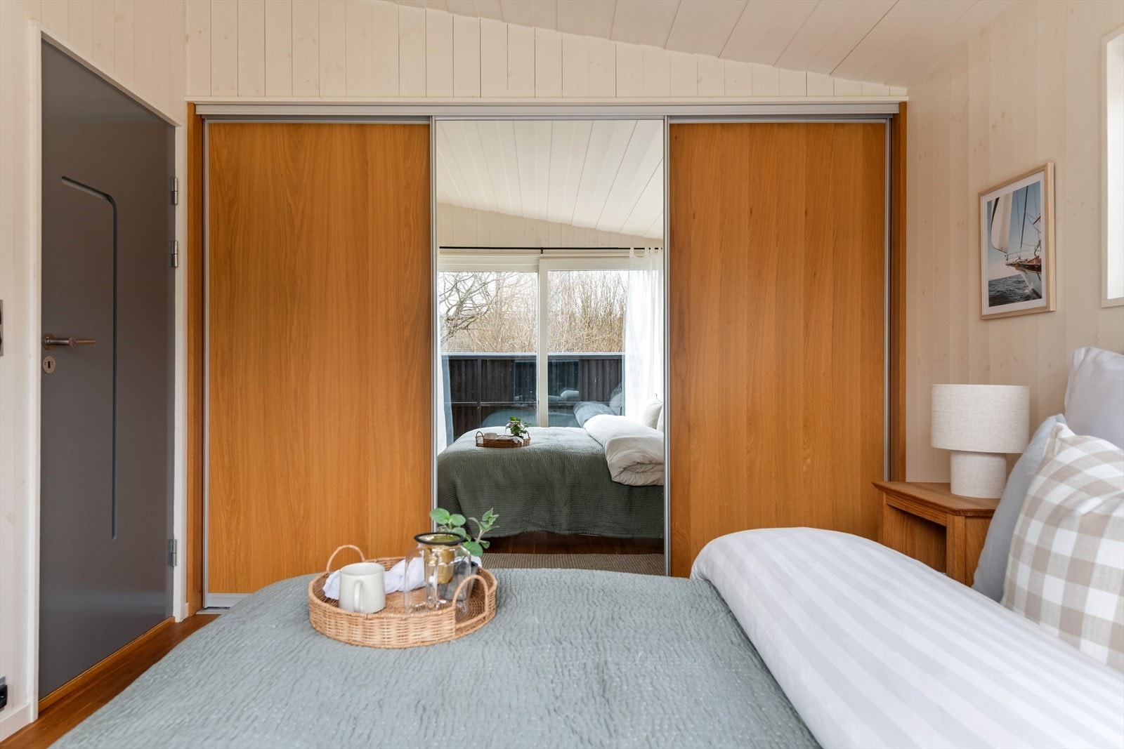 På det største soverommet er det god plass til dobbeltseng, nattbord og innholdsrik skyvedørsgarderobe langs den ene veggen. Galleribilde