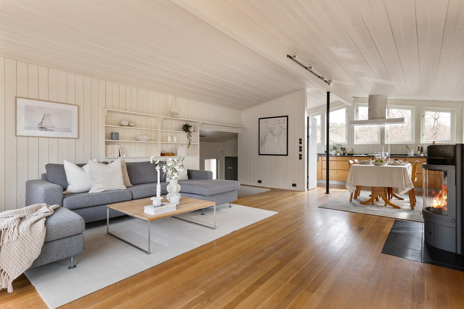 Overflatene er lyse med tre-stavs parkett og lysmalte panelvegger. Peisen sikrer behagelig varme. Galleribilde
