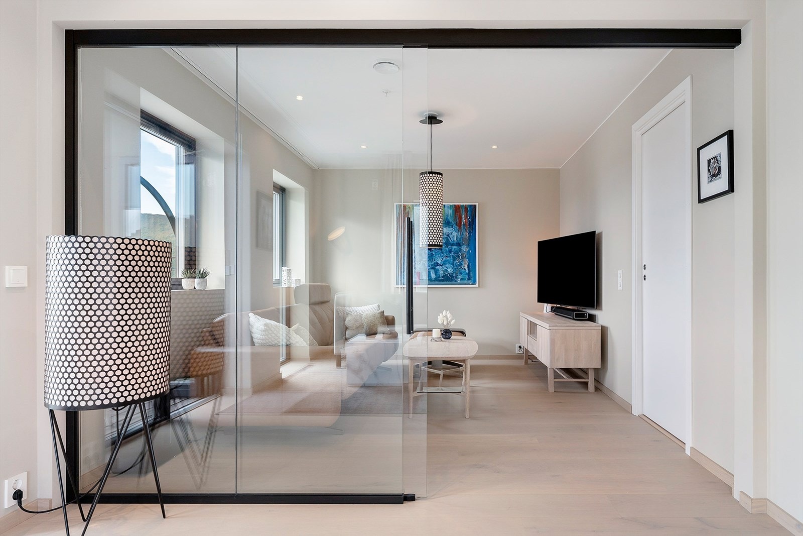 TV-stue adskilt fra stua med skyvedører i glass Galleribilde