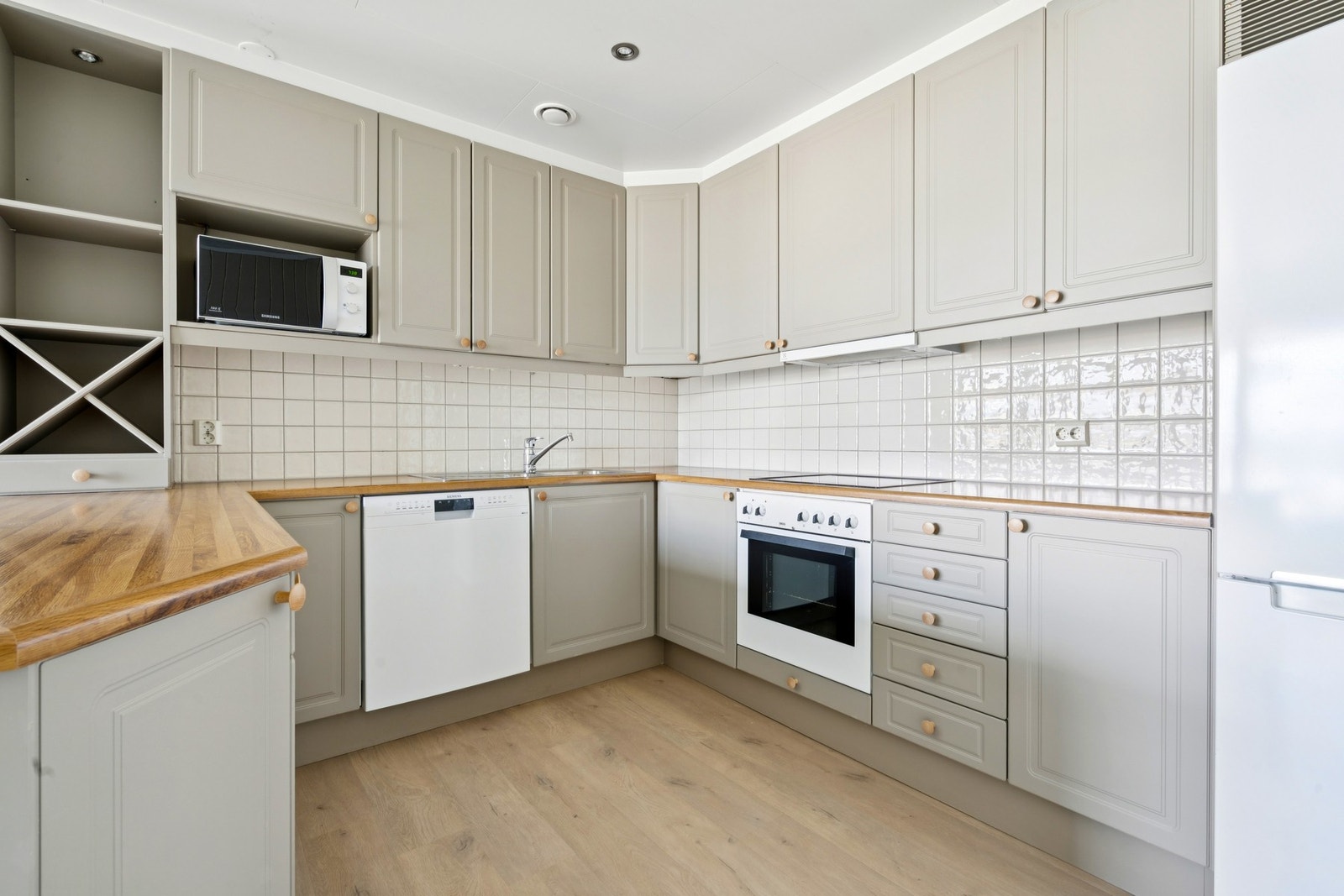 Kjøkken fremstår tidløst og moderne, med fliser over kjøkkenbenk Galleribilde