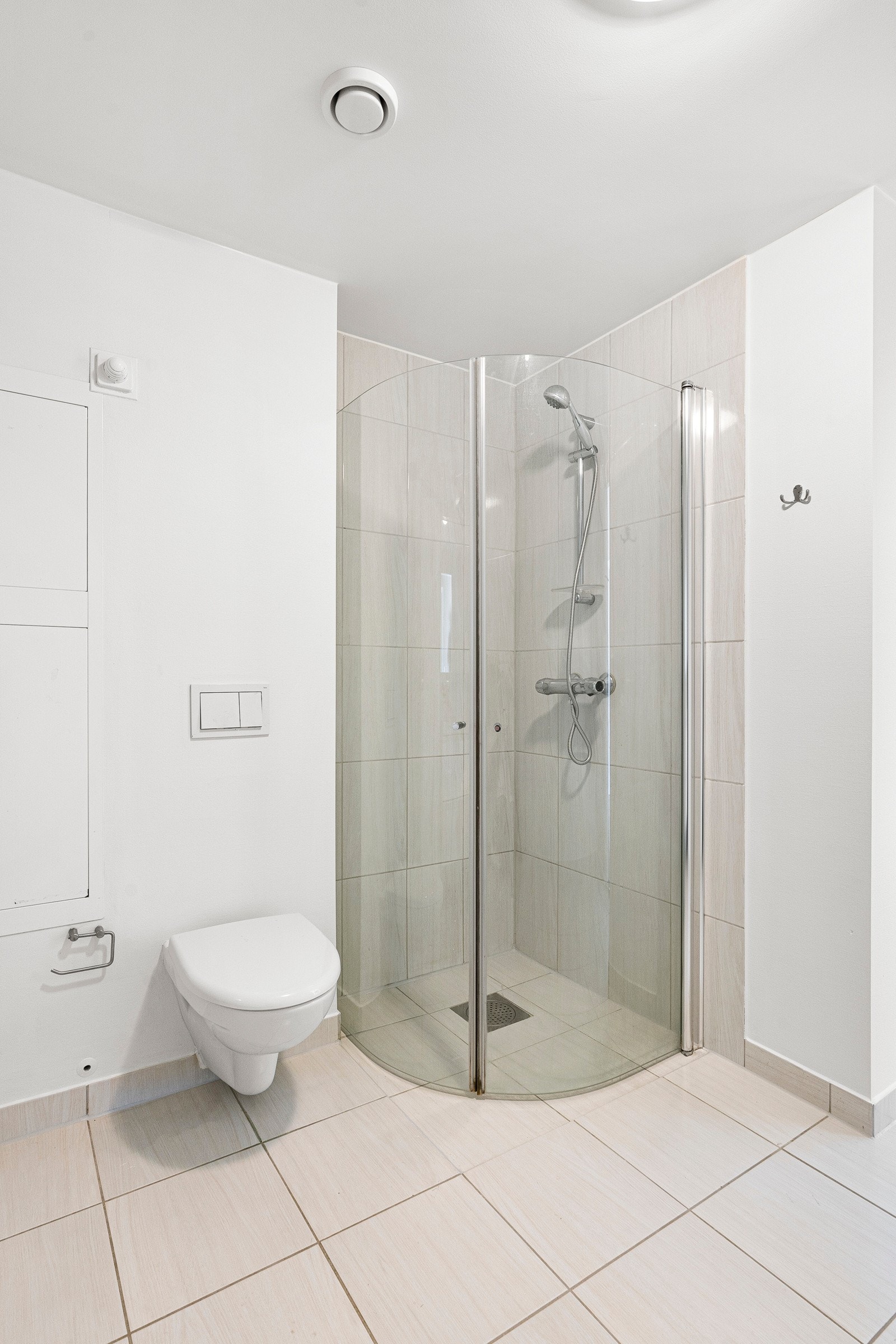 Badet er utstyrt med vegghengt toalett, dusj og vask i seksjon Galleribilde