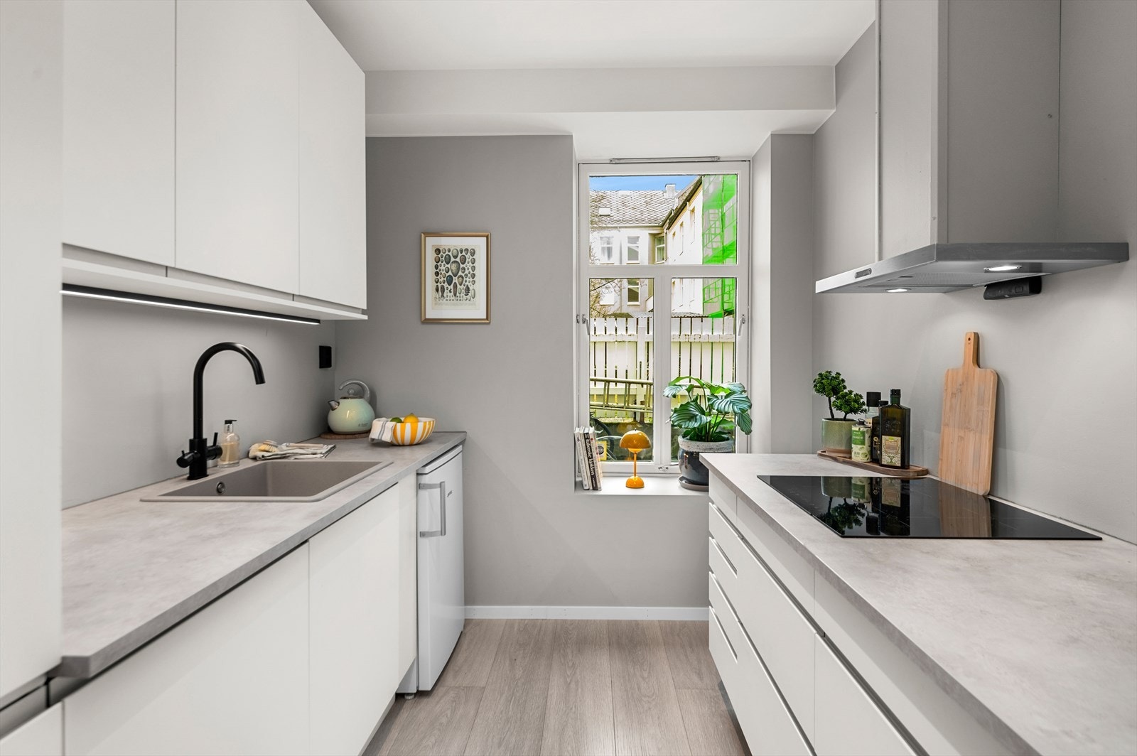 Kjøkkenet byr på integrerte hvitevarer som oppvaskmaskin, mikrobølgeovn, komfyr, platetopp og ventilator. Galleribilde