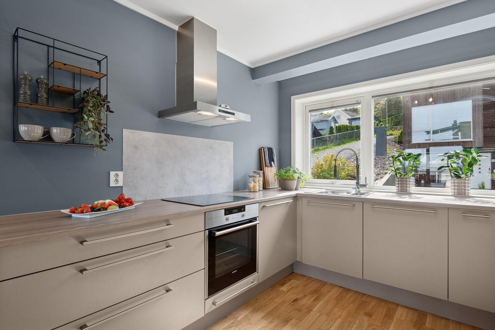 Kjøkkenet har moderne innredning med glatte fronter og en slitesterk benkeplate i laminat. Det er godt med skap- og benkeplass, noe som gjør det enkelt å holde orden og ha alt du trenger innen rekkevidde. Galleribilde