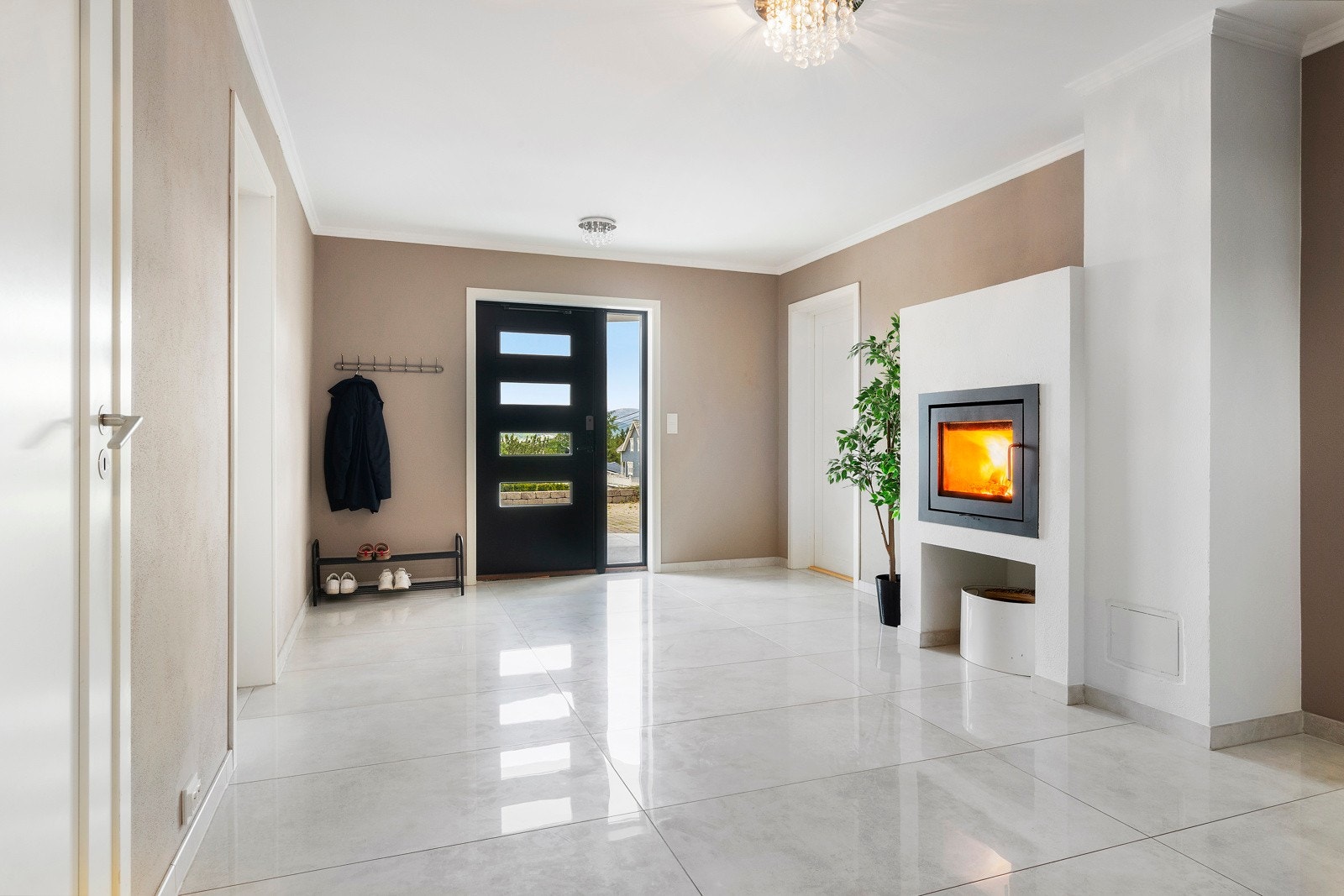 Velkommen inn. Hallen er flislagt med varme i gulvet og her er etablert ildsted. Galleribilde