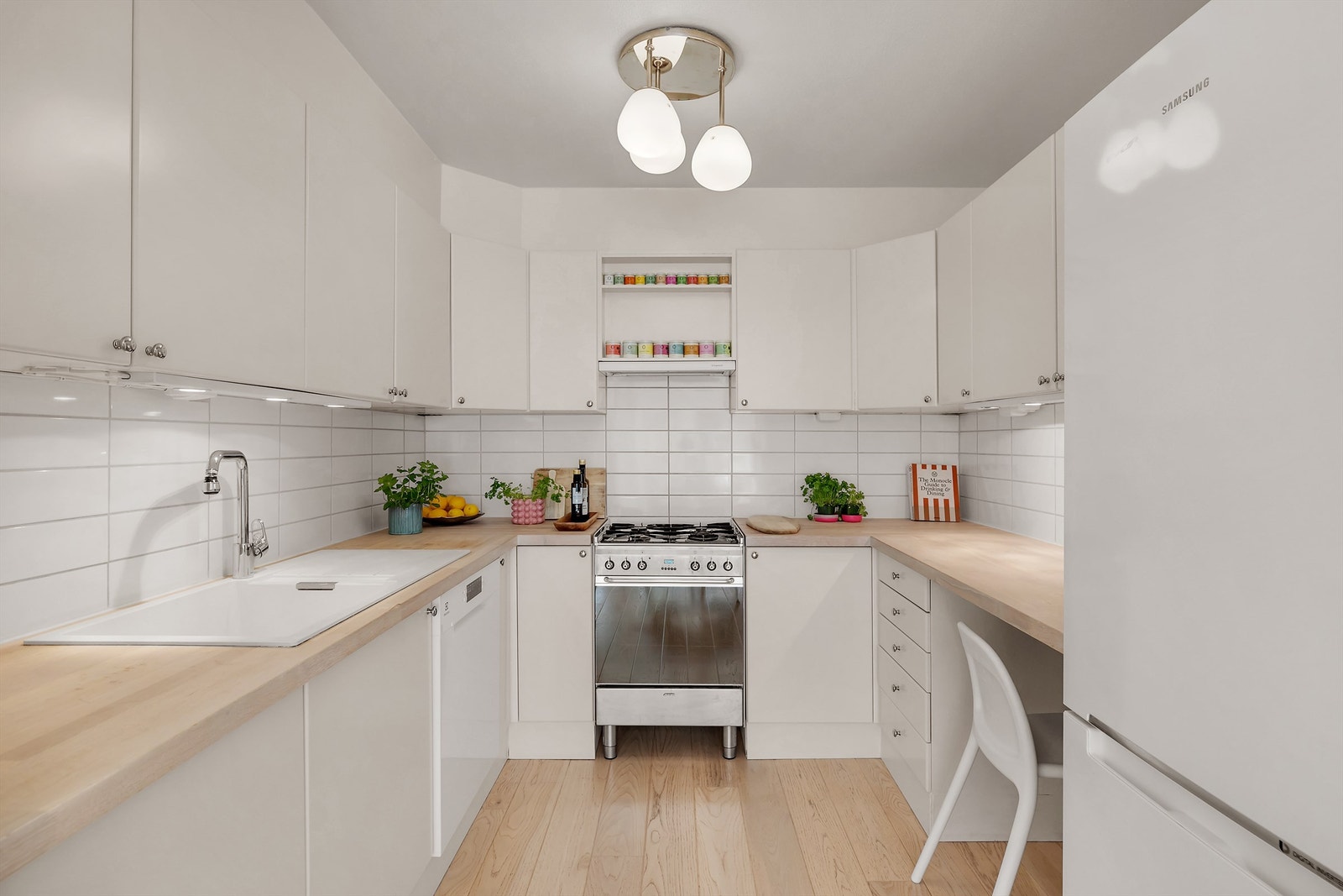 Praktisk kjøkkeninnredning fra byggeår med god plass til oppbevaring av kjøkkenredskaper og gode arbeidsflater for matlaging. Galleribilde