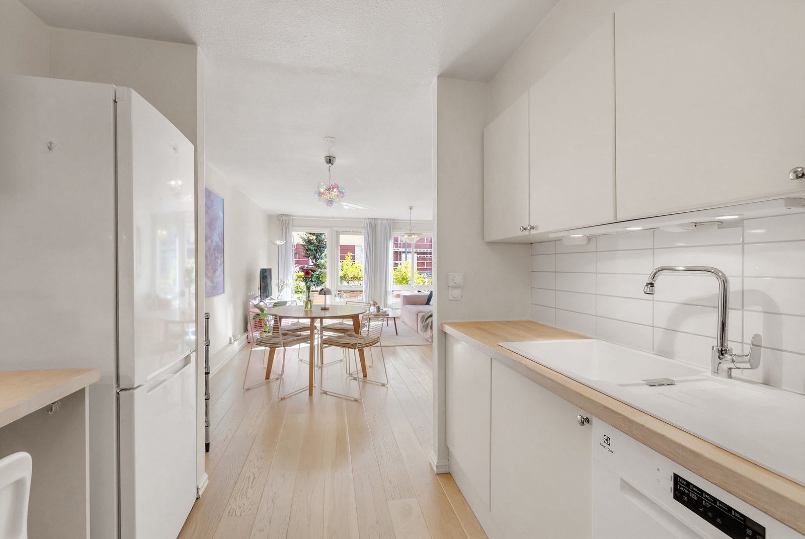 Kjøkkenet er innredet med benkeplate av tre, nedfelt oppvaskkum med ett greps armatur og frittstående hvitevarer som komfyr og kjøleskap med fryser. Galleribilde