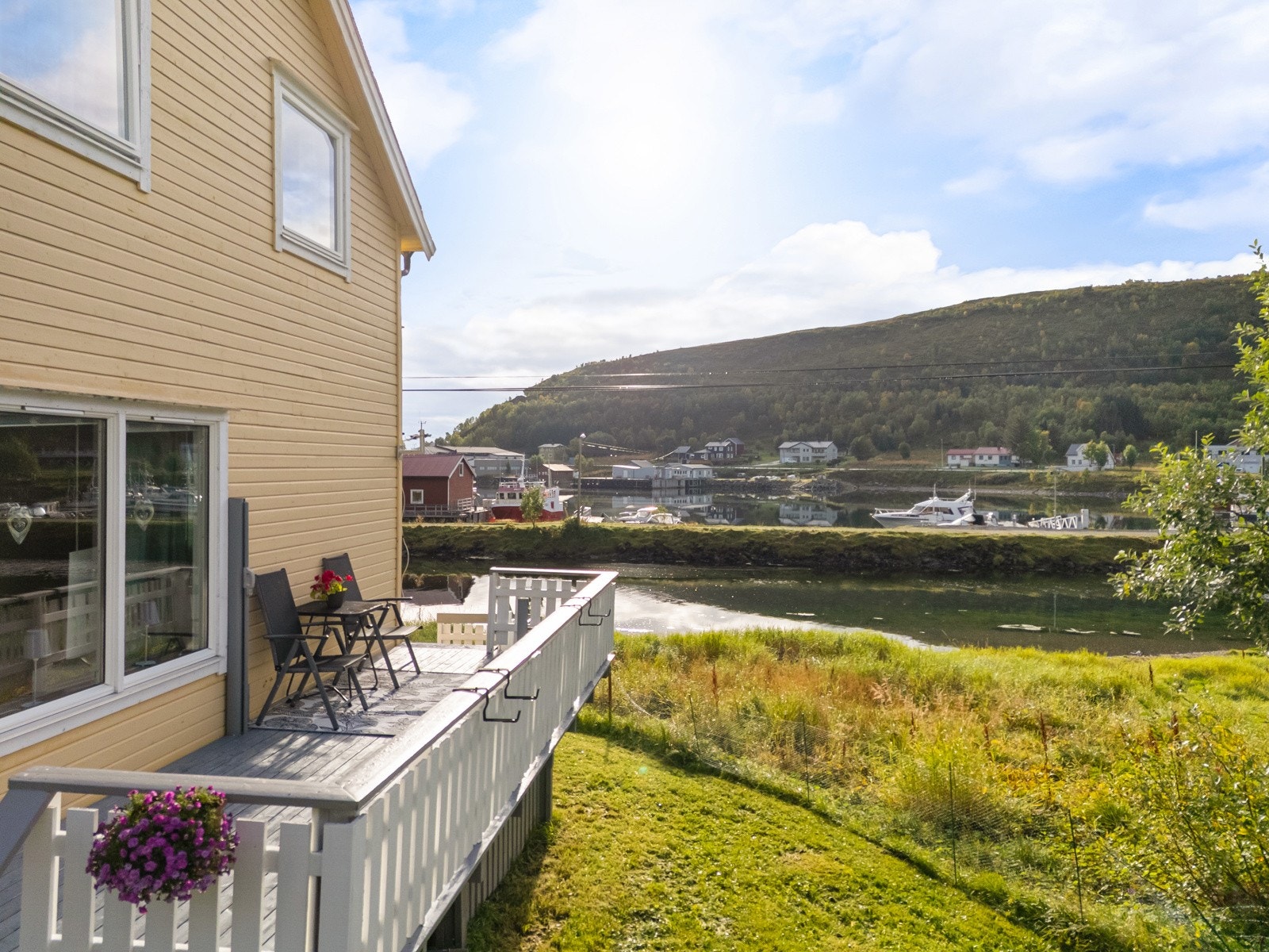 Stor veranda med god plass til hagemøbler og grill. Det er trapp ned til terrasse og hagearealet