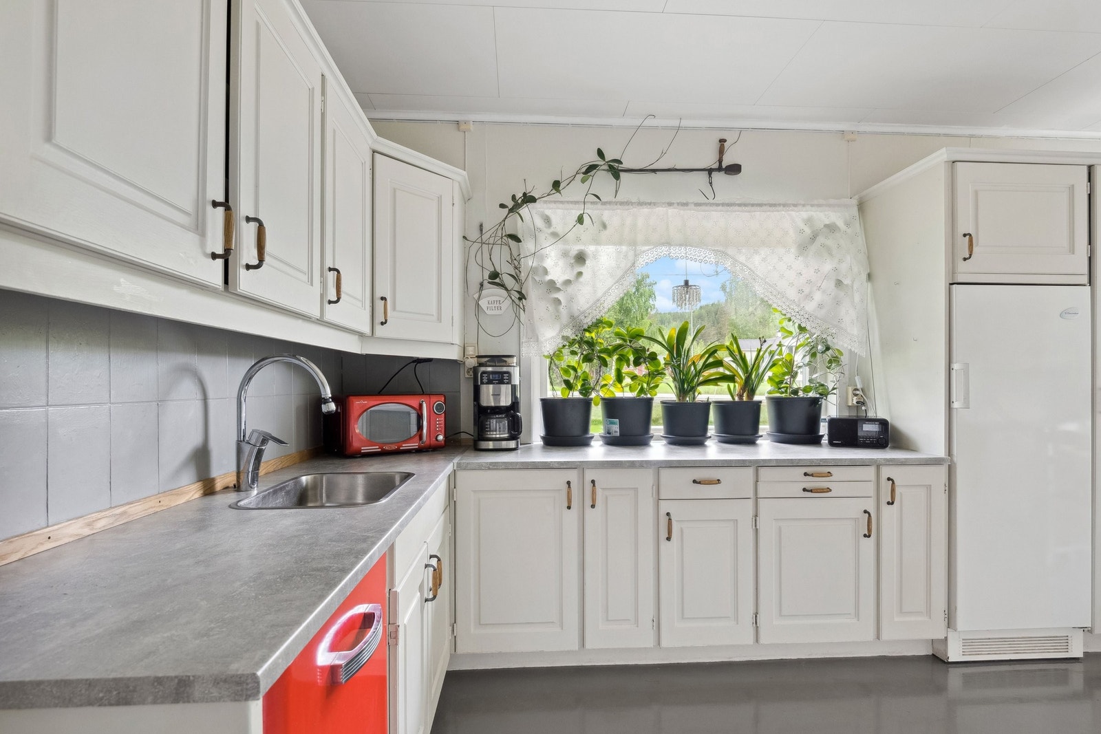 Vindu over kjøkkenbenk og godt med skapplass Galleribilde