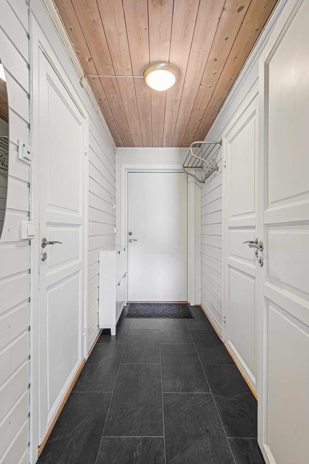 Lys entré med flislagt gulv og varmekabler. Det er plass for enkle garderobe- og opphengsløsninger. Galleribilde