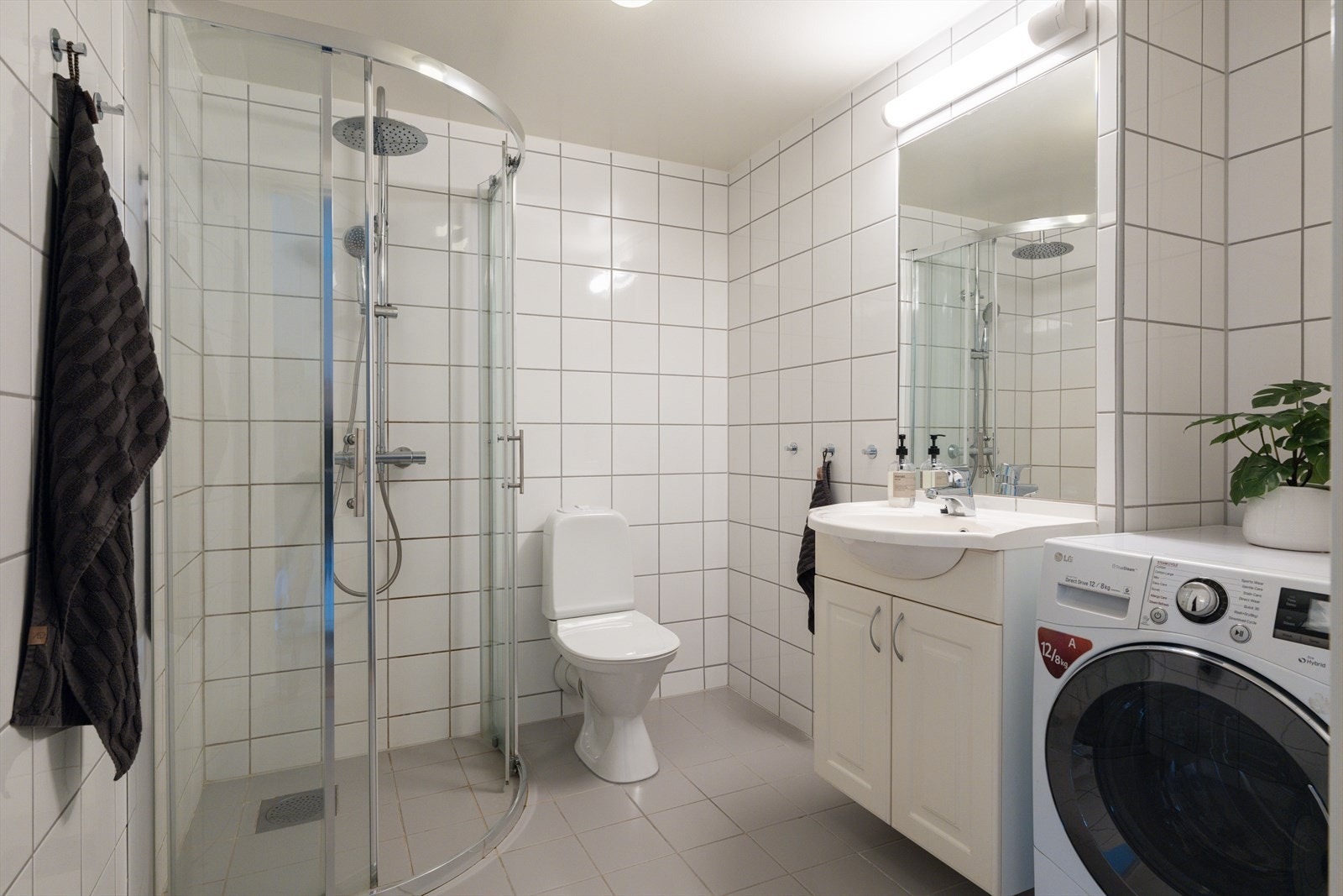 Praktisk bad med servant, speil og opplegg for vaskemaskin. Galleribilde