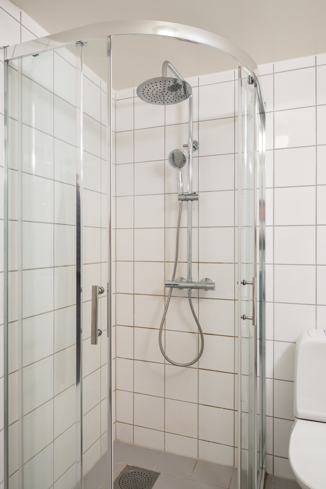 Romslig dusjhjørne med skyvedører, som er stilrent og praktisk. Galleribilde