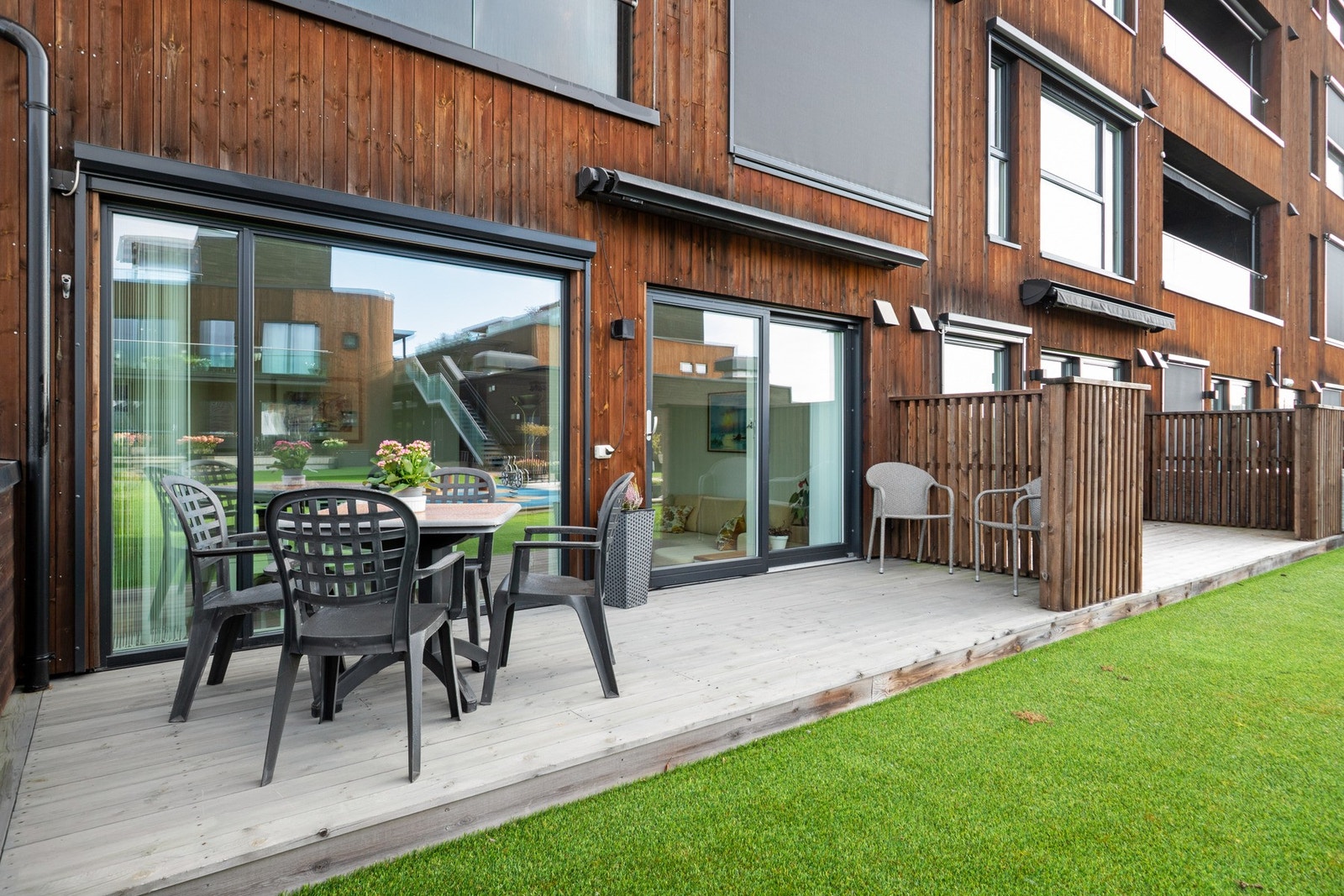 Terrassen har plass til utemøbler og grill, og er skjermet med høy levegg mot nabo. Galleribilde