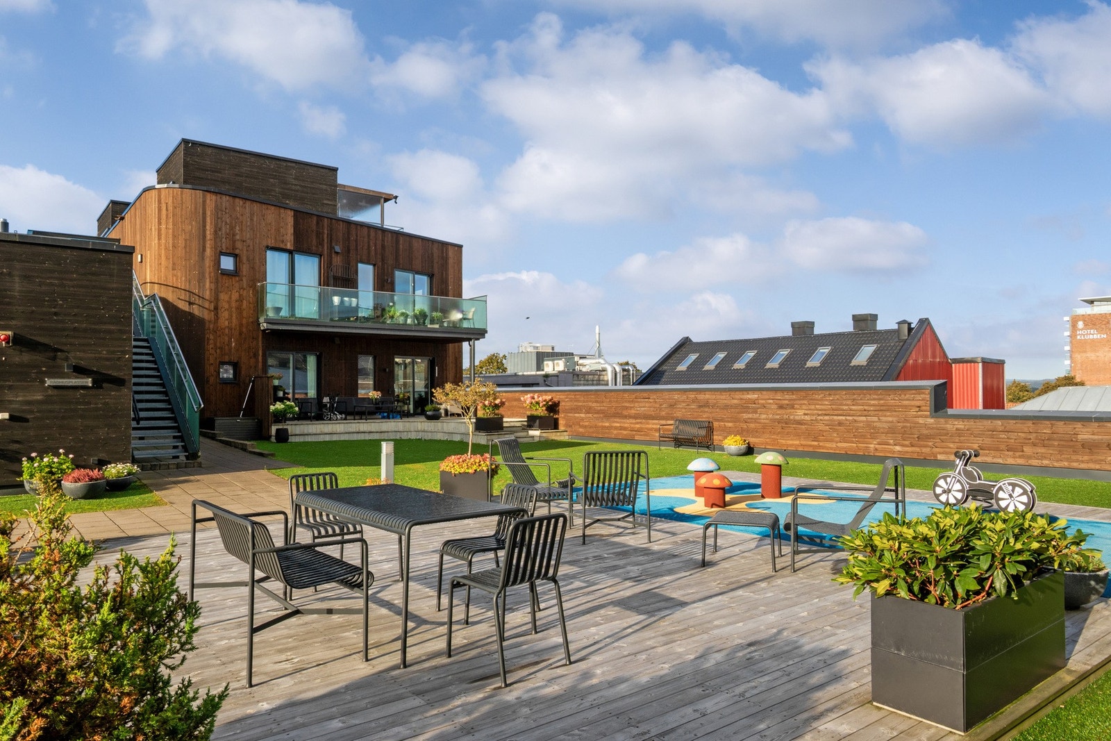 Atriet er opparbeidet med plen, hellelagte områder, sittegrupper og lekeplass. Galleribilde