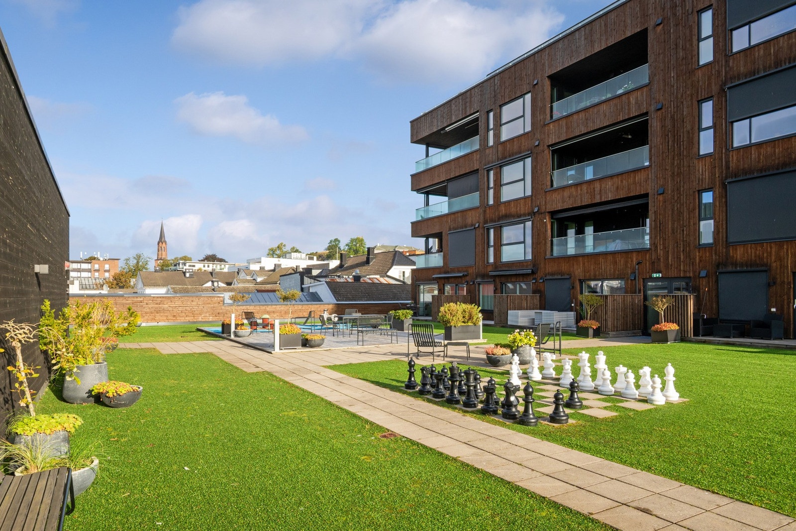 Utesjakk, benker og bord gjør dette til et trivelig og aktivt fellesområde. Galleribilde