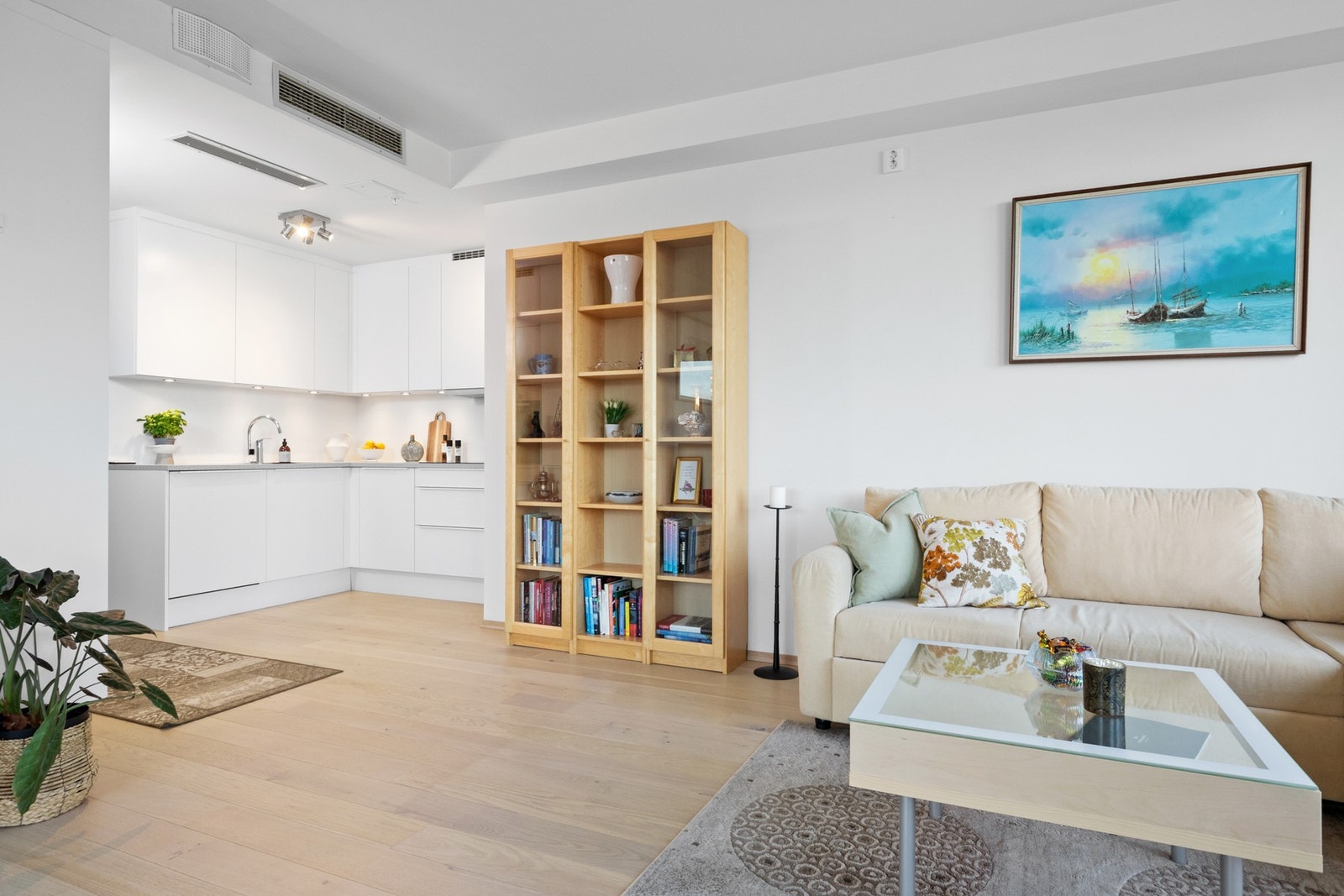 Stilrent kjøkken med hvite, glatte fronter og takhøye skap som gir rikelig med oppbevaringsplass. Galleribilde