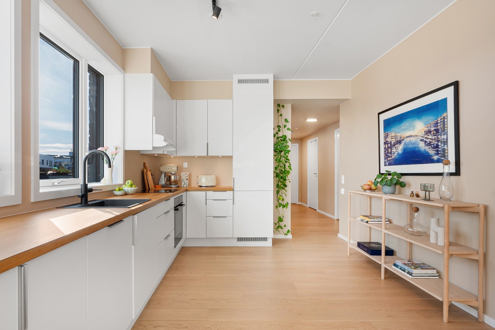 Kjøkkenet er funksjonelt og stilrent med glatte fronter og laminat benkeplate med nedfelt vask. Galleribilde