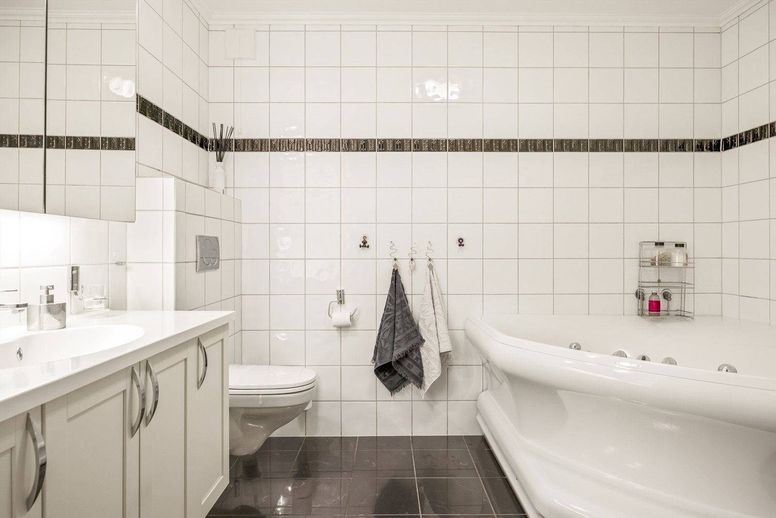 Baderom i underetasje som er utrustet med stor baderomsinnredning, vegghengt toalett og boblekar. Galleribilde