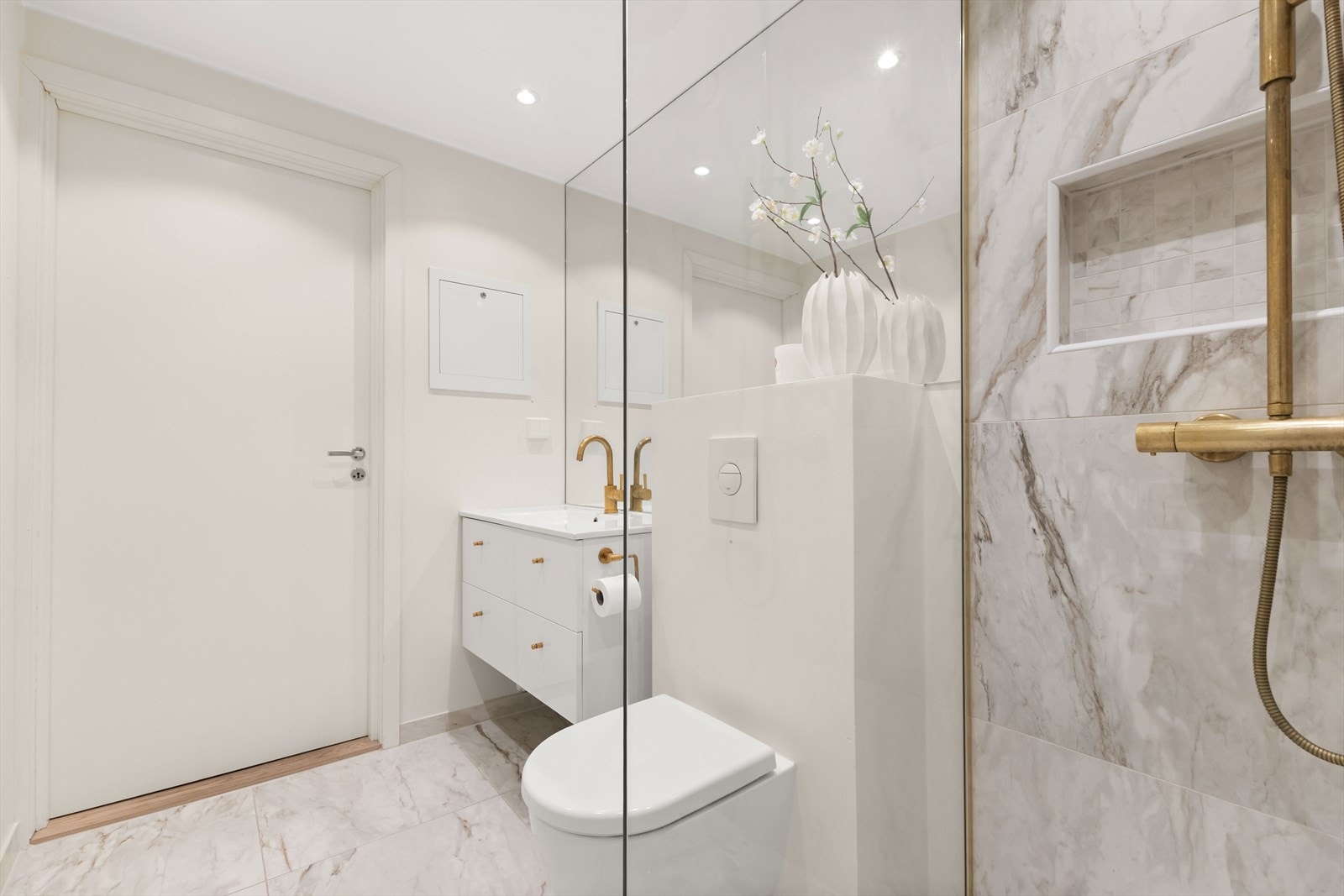 Eksklusivt bad med lekre detaljer, store fliser, varme i gulv, servant med innredning og vegghengt toalett Galleribilde